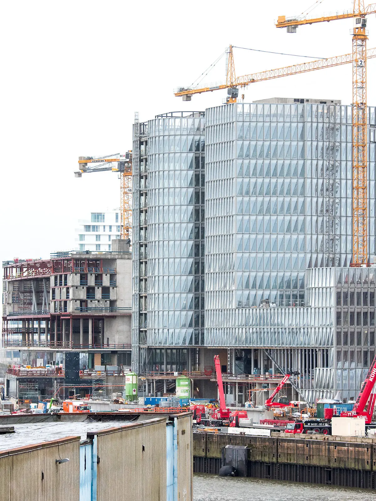 31.10.2023, Hamburg: Einsatzfahrzeuge und Kräne stehen in der Hafencity auf einer Baustelle. Nach dem verheerenden Unfall auf einer Großbaustelle mit vier Toten gehen am Dienstag die Ermittlungen zur Unglücksursache weiter. Foto: Daniel Bockwoldt/dpa +++ dpa-Bildfunk +++