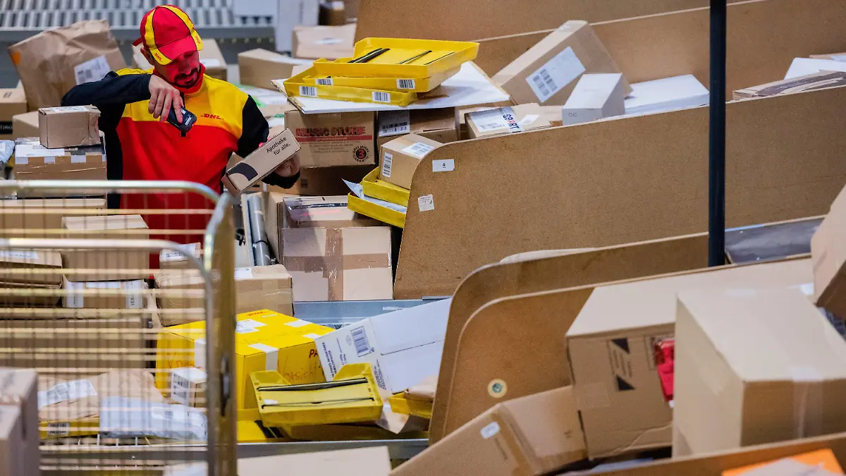 19.10.2022, Nordrhein-Westfalen, Köln: Ein Paketzusteller sortiert und räumt in einer Zustellbasis von Deutsche Post DHL Pakete in ein Zustellfahrzeug. Im diesjährigen Weihnachtsgeschäft rechnet die Deutsche Post DHL wieder mit Paketmassen. Foto: Rolf Vennenbernd/dpa +++ dpa-Bildfunk +++