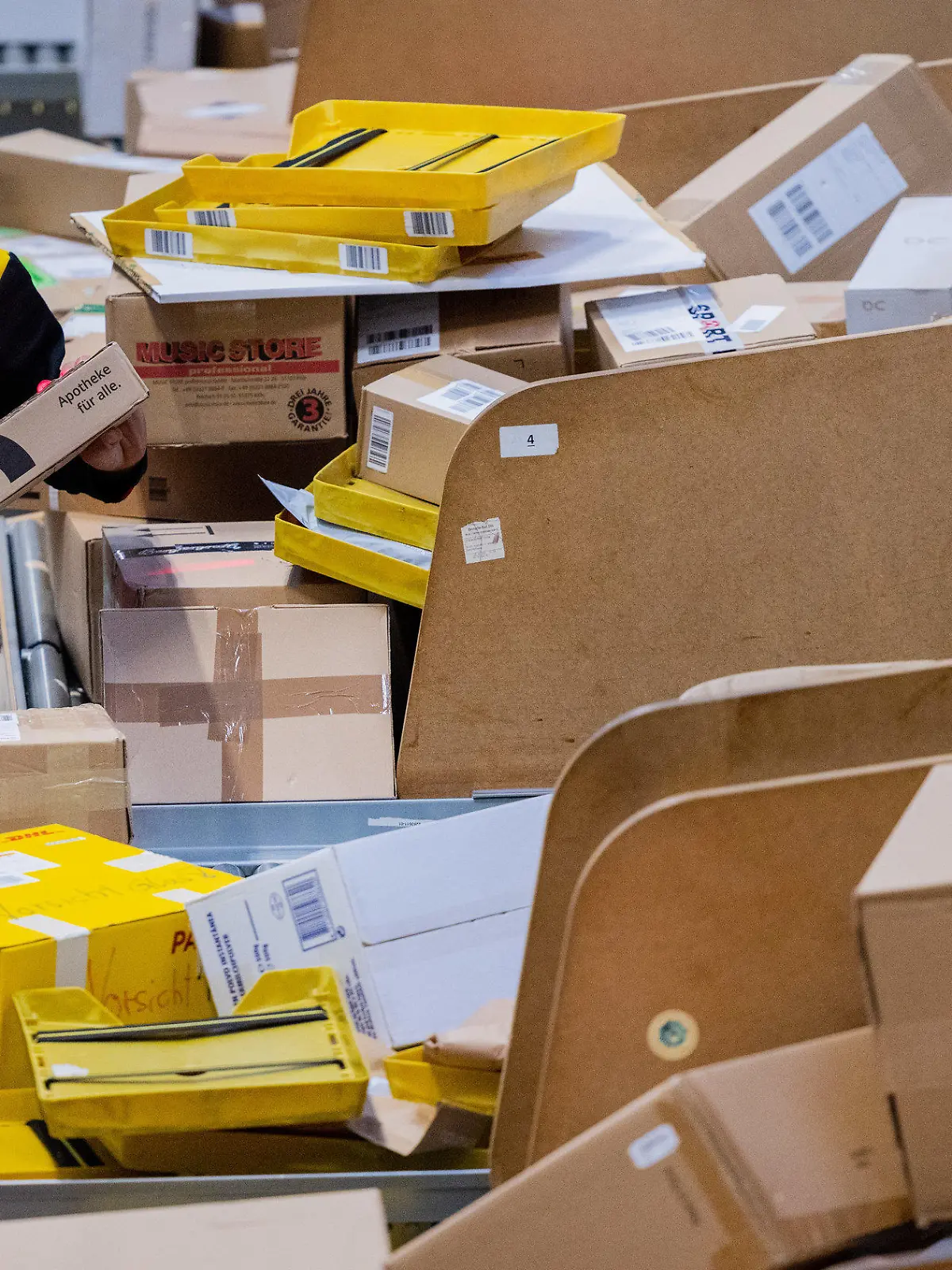 19.10.2022, Nordrhein-Westfalen, Köln: Ein Paketzusteller sortiert und räumt in einer Zustellbasis von Deutsche Post DHL Pakete in ein Zustellfahrzeug. Im diesjährigen Weihnachtsgeschäft rechnet die Deutsche Post DHL wieder mit Paketmassen. Foto: Rolf Vennenbernd/dpa +++ dpa-Bildfunk +++