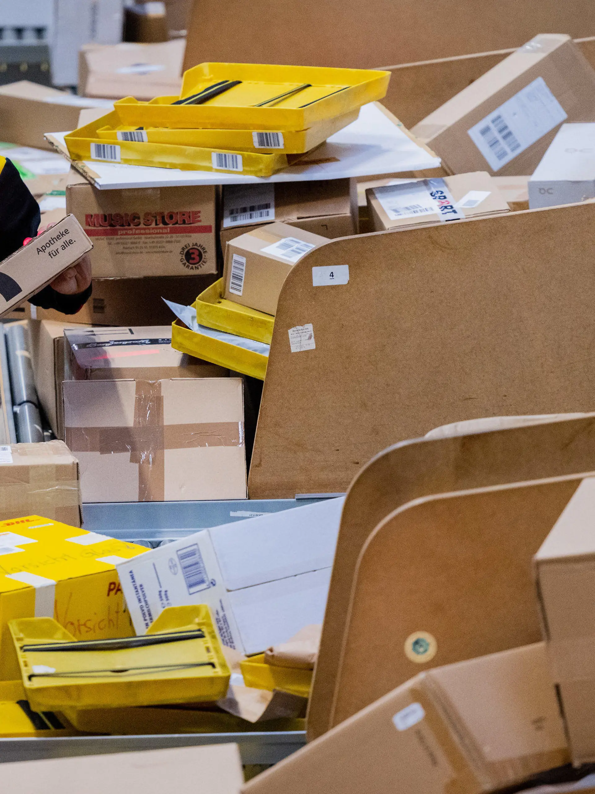 19.10.2022, Nordrhein-Westfalen, Köln: Ein Paketzusteller sortiert und räumt in einer Zustellbasis von Deutsche Post DHL Pakete in ein Zustellfahrzeug. Im diesjährigen Weihnachtsgeschäft rechnet die Deutsche Post DHL wieder mit Paketmassen. Foto: Rolf Vennenbernd/dpa +++ dpa-Bildfunk +++