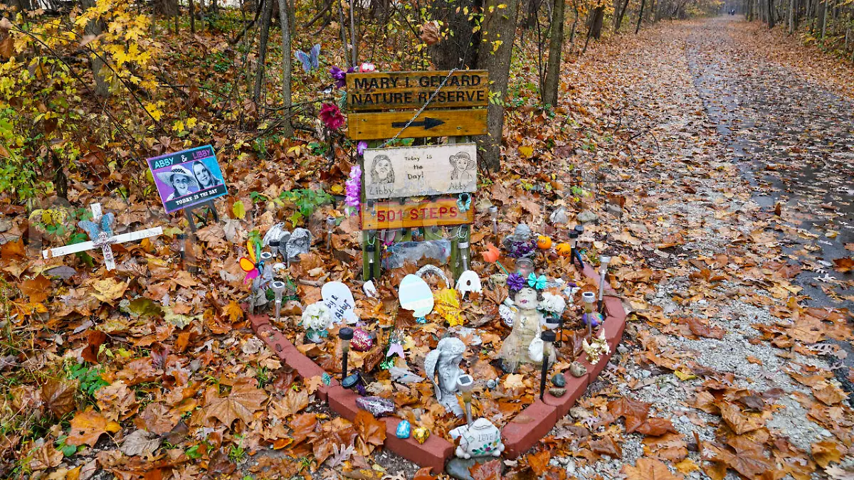 A makeshift memorial to Liberty German, and Abigail Williams near where they were last seen and where the bodies were discovered stands along the Monon Trail leading to the Monon High Bridge Trail in Delphi, Ind., Monday, Oct. 31, 2022. The Indiana State Police announced an arrest in the murders of the two teenage girls killed during a 2017 hiking trip in northern Indiana. (AP Photo/Michael Conroy)