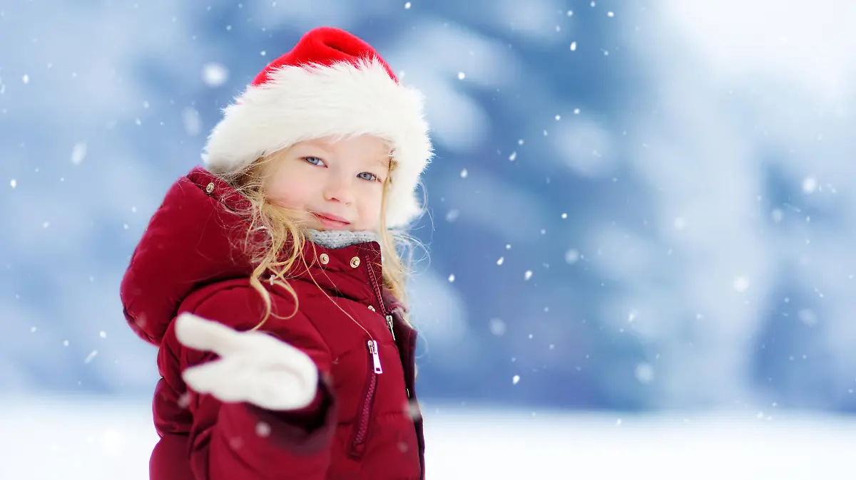Adorable little girl having fun in beautiful winter park. Cute child playing in a snow. Winter activities for kids.