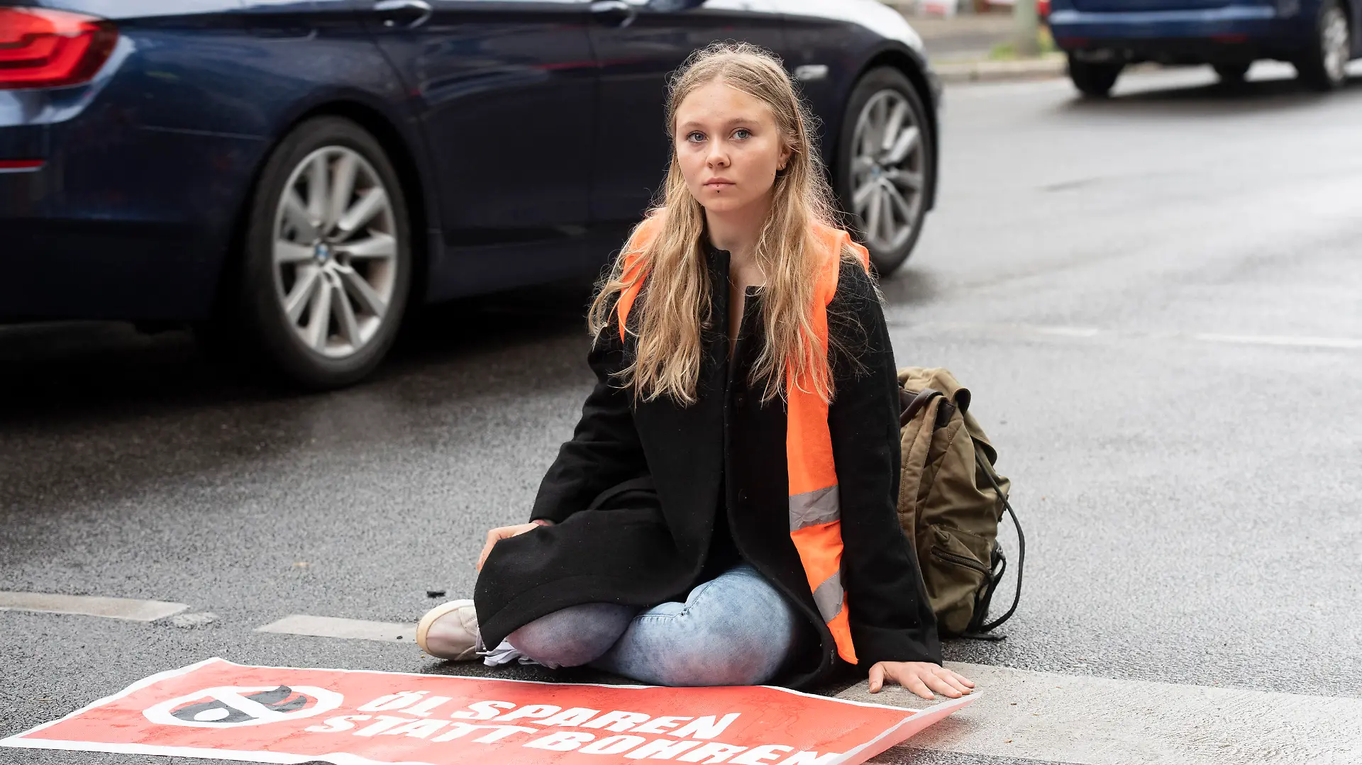 Klimaschutz-Demonstrantin Aimée van Baalen (22) sitzt unweit der Wetraße auf der Fahrbahn. Mitglieder der Gruppe "Letzte Generation" haben nach einer längeren Pause heute wieder ahlreiche Straßen in der Stadt blockiert.