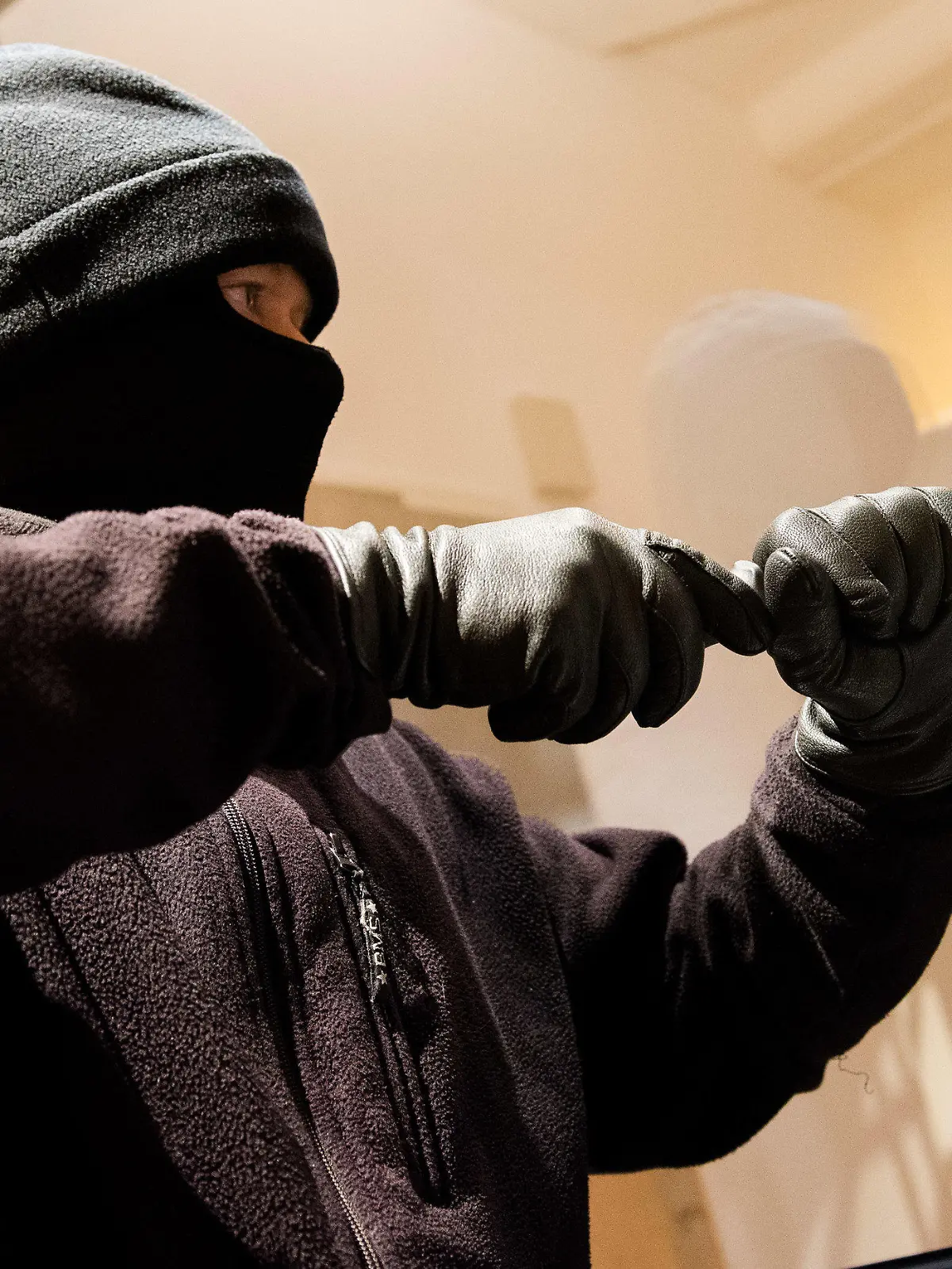 ARCHIV - 28.06.2016, Hamburg: Ein als Einbrecher verkleideter Mann hebelt in der Kriminalpolizeilichen Beratungsstelle der Polizei ein Fenster auf.     (zu dpa «Zahl der Einbrüche in Hamburg um 30 Prozent gestiegen») Foto: picture alliance / dpa +++ dpa-Bildfunk +++