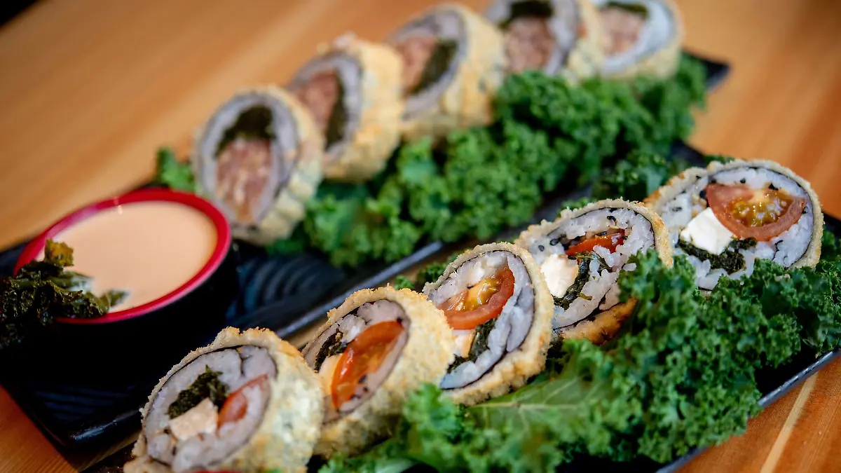 Sushi mit Grünkohl, Tomaten und Feta (vorne) sowie Sushi mit Grünkohl und Pinkel steht im Restaurant Moto Kitchen auf einem Tisch.