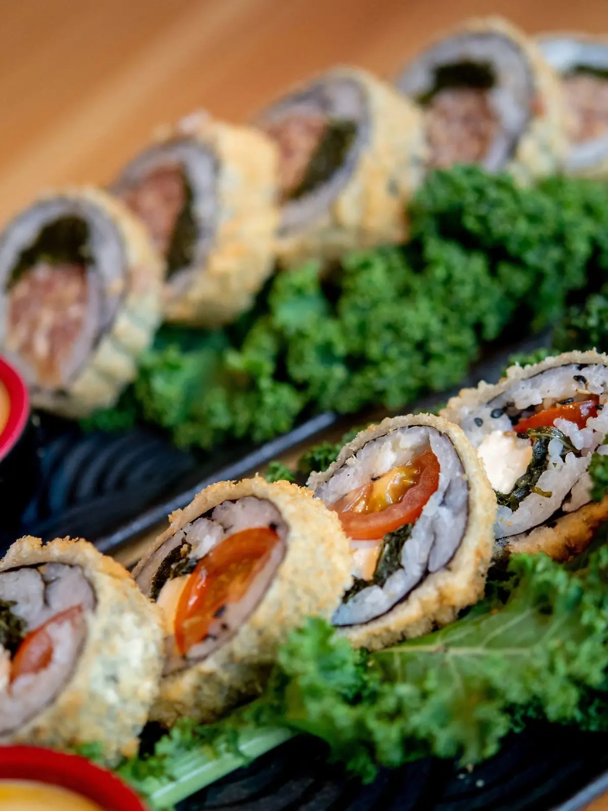 Sushi mit Grünkohl, Tomaten und Feta (vorne) sowie Sushi mit Grünkohl und Pinkel steht im Restaurant Moto Kitchen auf einem Tisch.