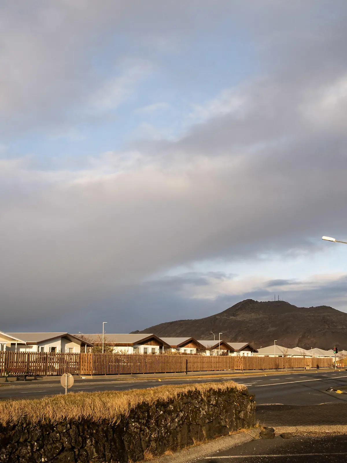 10.11.2023, Island, Grindavik: Eine Straße in Grindavik mit dem Berg Þorbjörn im Hintergrund. Aufgrund der anhaltenden schweren Erdbebenserie auf Island warnen die Behörden auf der Nordatlantik-Insel vor noch stärkeren Beben und einem möglicherweise bevorstehenden Vulkanausbruch. Die Erschütterungen in der Nähe des Ortes Grindavík könnten noch heftiger werden und letztlich zu einer Eruption führen, teilte die isländische Polizei am Freitagabend mit. Vorsichtshalber sei die Evakuierung der Ortschaft angeordnet worden. Foto: Raul Moreno/SOPA Images via ZUMA Press Wire/dpa +++ dpa-Bildfunk +++