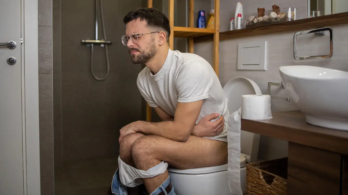 Young man in pain gong through his morning routine at toilet