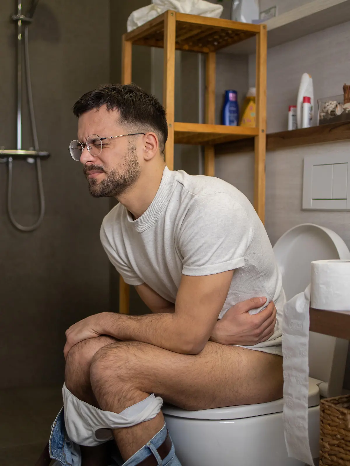 Young man in pain gong through his morning routine at toilet
