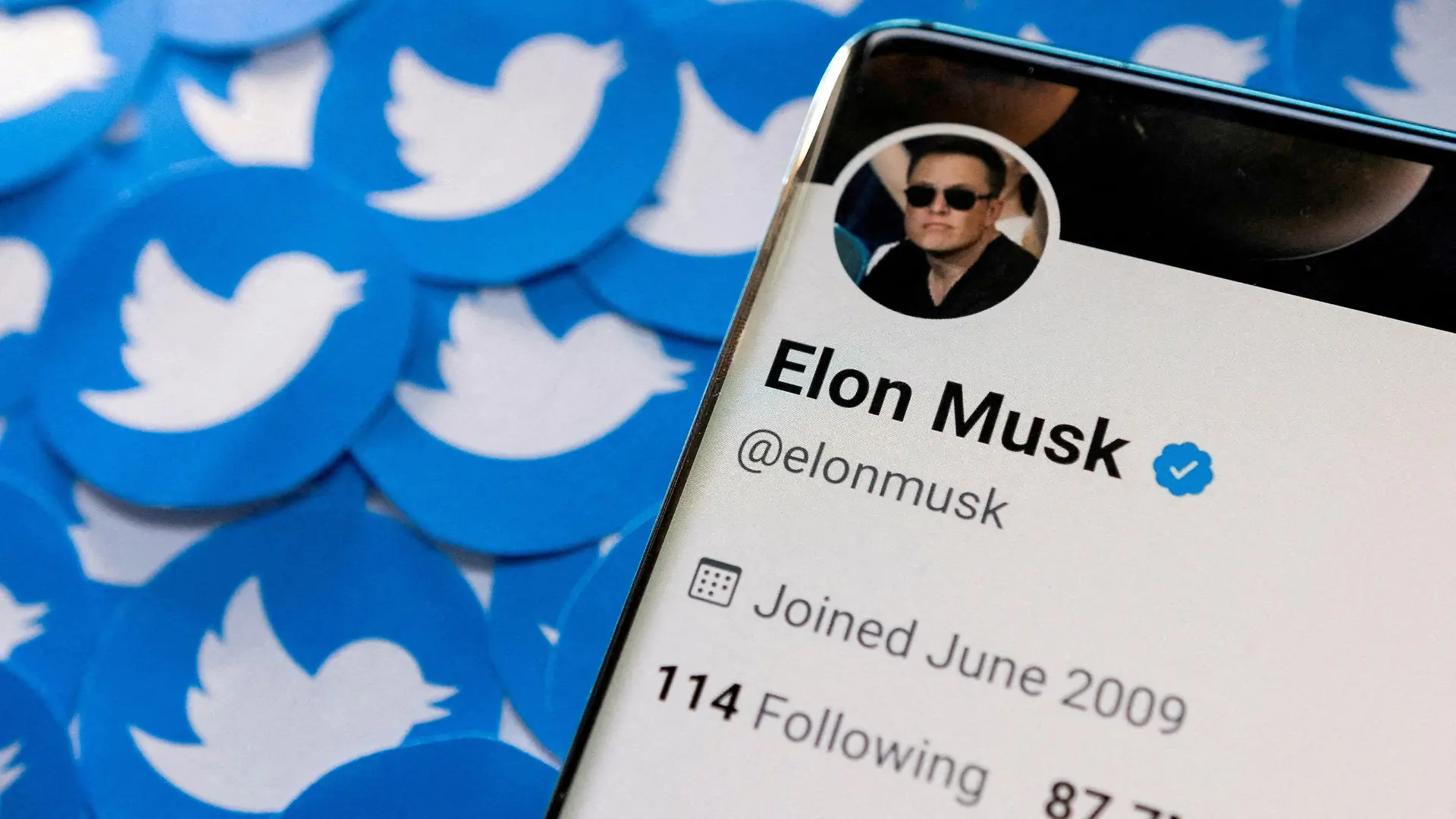 FILE PHOTO: Elon Musk's Twitter profile is seen on a smartphone placed on printed Twitter logos in this picture illustration taken April 28, 2022. REUTERS/Dado Ruvic/Illustration/File Photo
