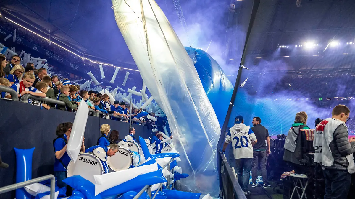 Fußball: Bundesliga, FC Schalke 04 - SC Freiburg, 12. Spieltag, Veltins Arena: Im Stadiongraben liegen nach dem Anpfiff die Reste der Choreographie. Der blaue Rauch der Pyrotechnik zieht auf das Spielfeld.