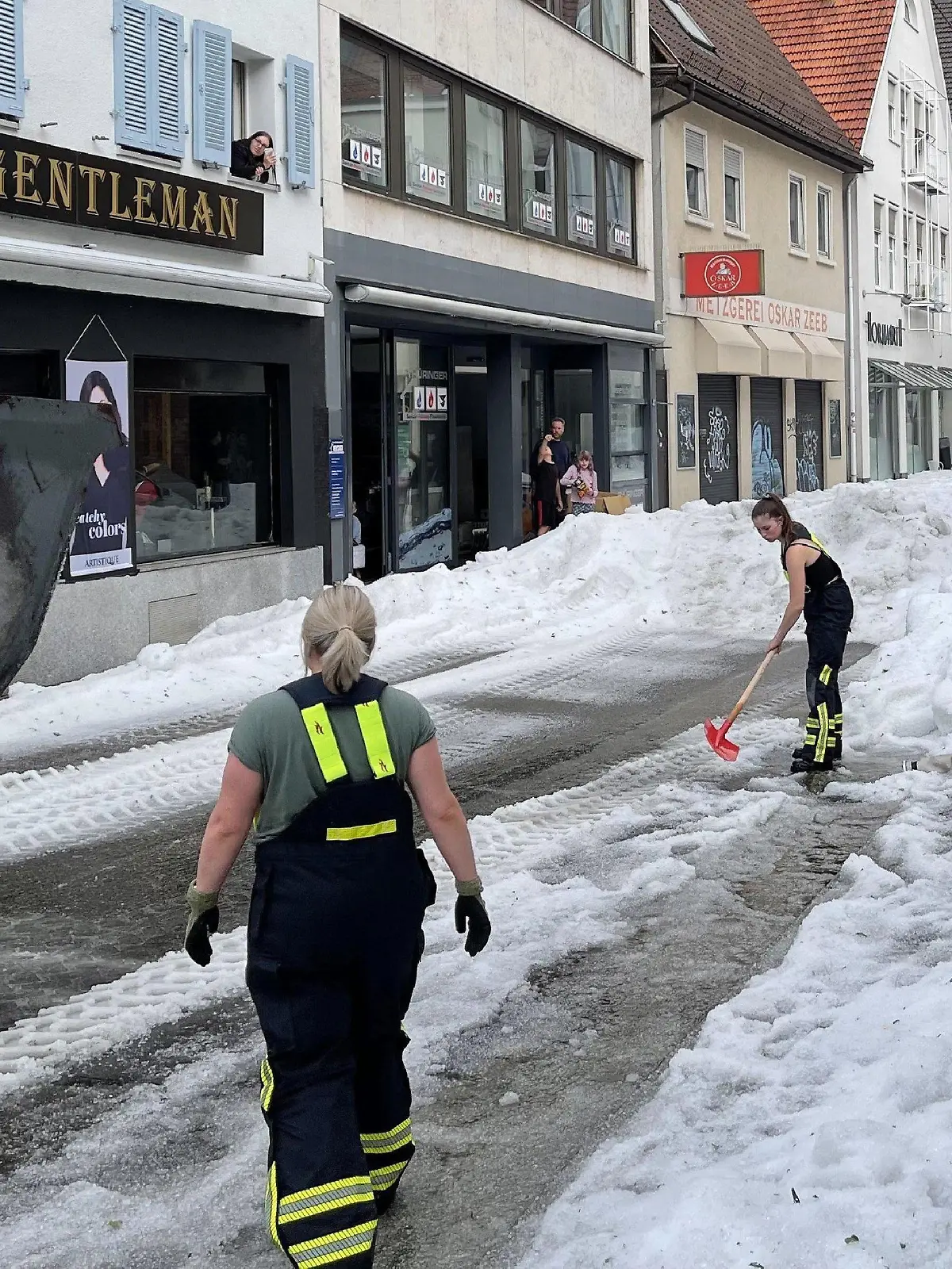 04.08.2023, Baden-Württemberg, Reutlingen: Einsatzkräfte der Feuerwehr räumen Hagel von einer Straße. Winterdienst-Einsatz mitten im Sommer: Ein lokal begrenztes Unwetter hat Straßen in der Innenstadt von Reutlingen mit einer hohen Hagel-Schicht überzogen. Foto: Schulz/SDMG/dpa +++ dpa-Bildfunk +++