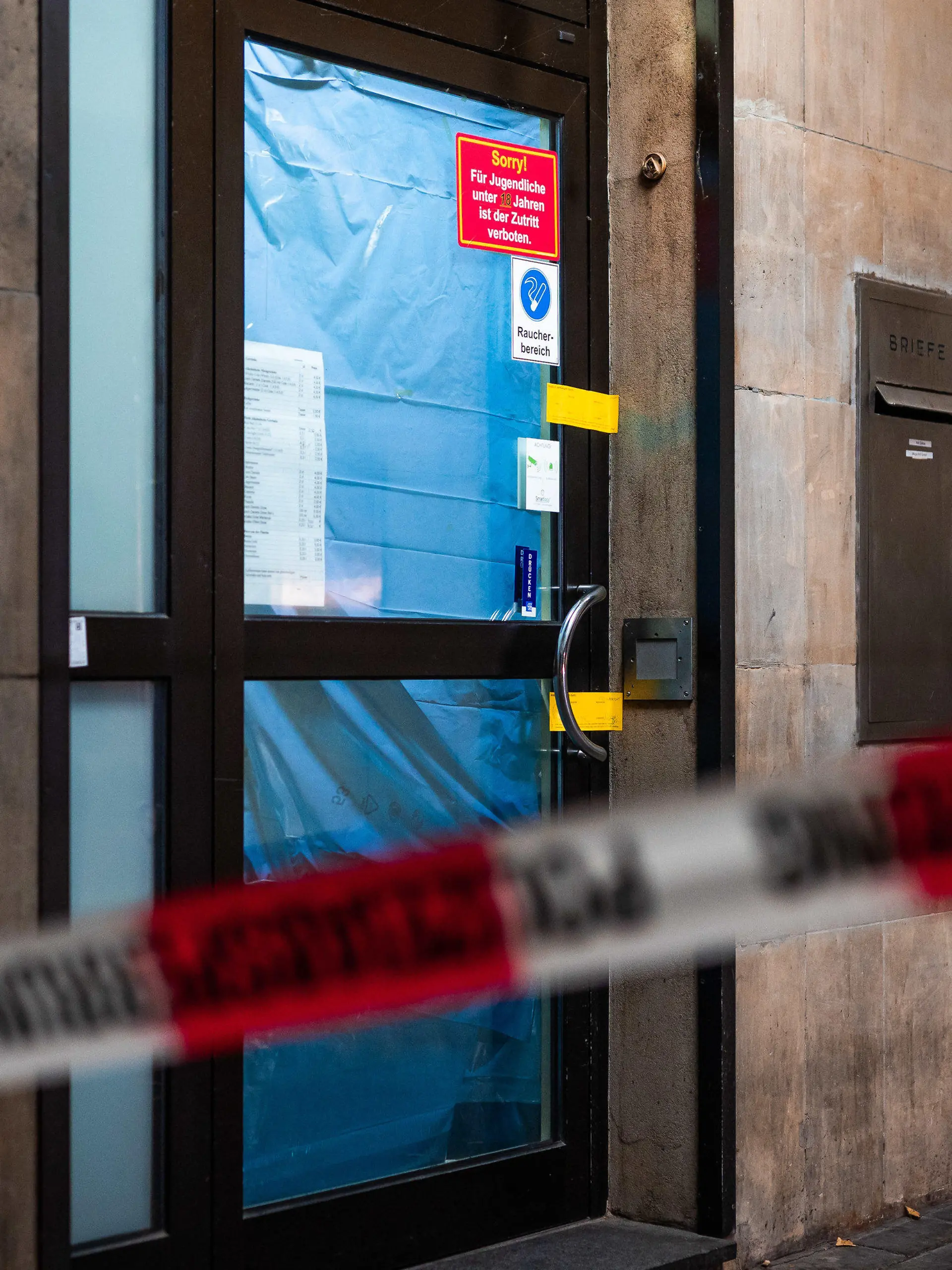 14.11.2023, Niedersachsen, Hannover: Absperrband weht in der Nacht vor dem polizeilich versiegelten Eingang einer Spielothek. In der Spielothek wurde ein Mann mit einer Stichwaffe tödlich verletzt. Foto: Moritz Frankenberg/dpa +++ dpa-Bildfunk +++
