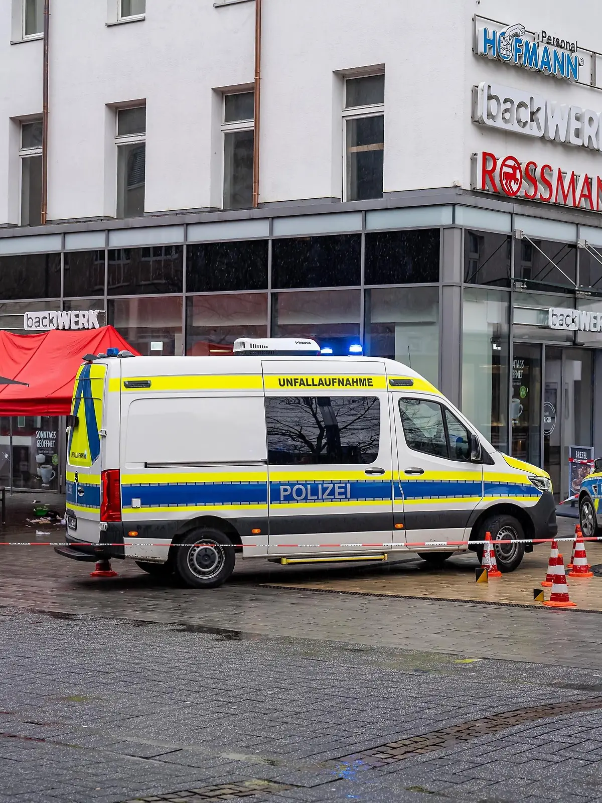 14.11.2023, Nordrhein-Westfalen, Gummersbach: Einsatzfahrzeuge der Polizei stehen am Tatort in der Innenstadt. Nach Schüssen mit mehreren Verletzten hat die Polizei den Tatort weiträumig abgesperrt. Ein Polizist habe mit seiner Dienstwaffe geschossen und damit mindestens einen Menschen verletzt, berichteten Polizeisprecher. Foto: Markus Klümper/dpa +++ dpa-Bildfunk +++