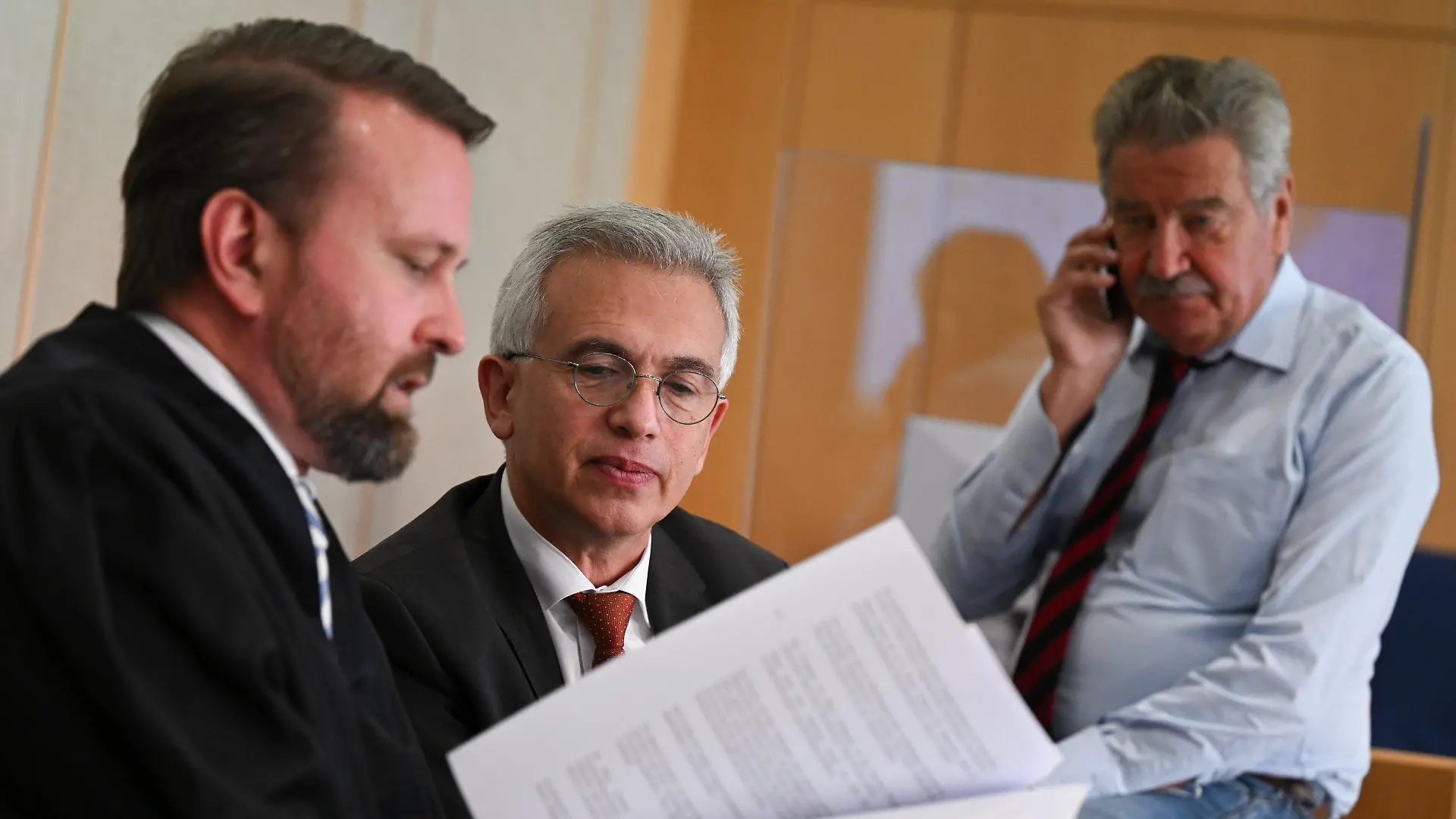 27.10.2022, Hessen, Frankfurt/Main: Peter Feldmann (SPD, M), Oberbürgermeister von Frankfurt am Main, unterhält sich während einer Pause des zweiten Prozesstages im Gerichtssaal des Landgerichts mit seinen Anwälten David Hofferbert (l) und Ulrich Endres. Der umstrittene Oberbürgermeister muss sich vor dem Landgericht wegen Korruptionsvorwürfen verantworten. Foto: Arne Dedert/dpa/POOL/dpa +++ dpa-Bildfunk +++