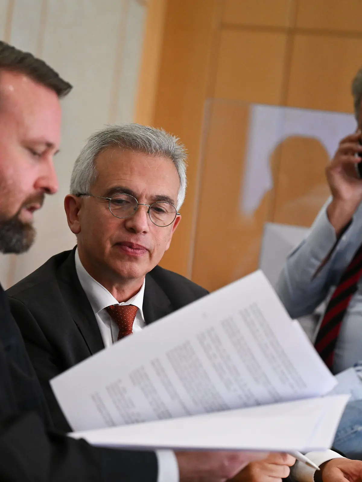 27.10.2022, Hessen, Frankfurt/Main: Peter Feldmann (SPD, M), Oberbürgermeister von Frankfurt am Main, unterhält sich während einer Pause des zweiten Prozesstages im Gerichtssaal des Landgerichts mit seinen Anwälten David Hofferbert (l) und Ulrich Endres. Der umstrittene Oberbürgermeister muss sich vor dem Landgericht wegen Korruptionsvorwürfen verantworten. Foto: Arne Dedert/dpa/POOL/dpa +++ dpa-Bildfunk +++