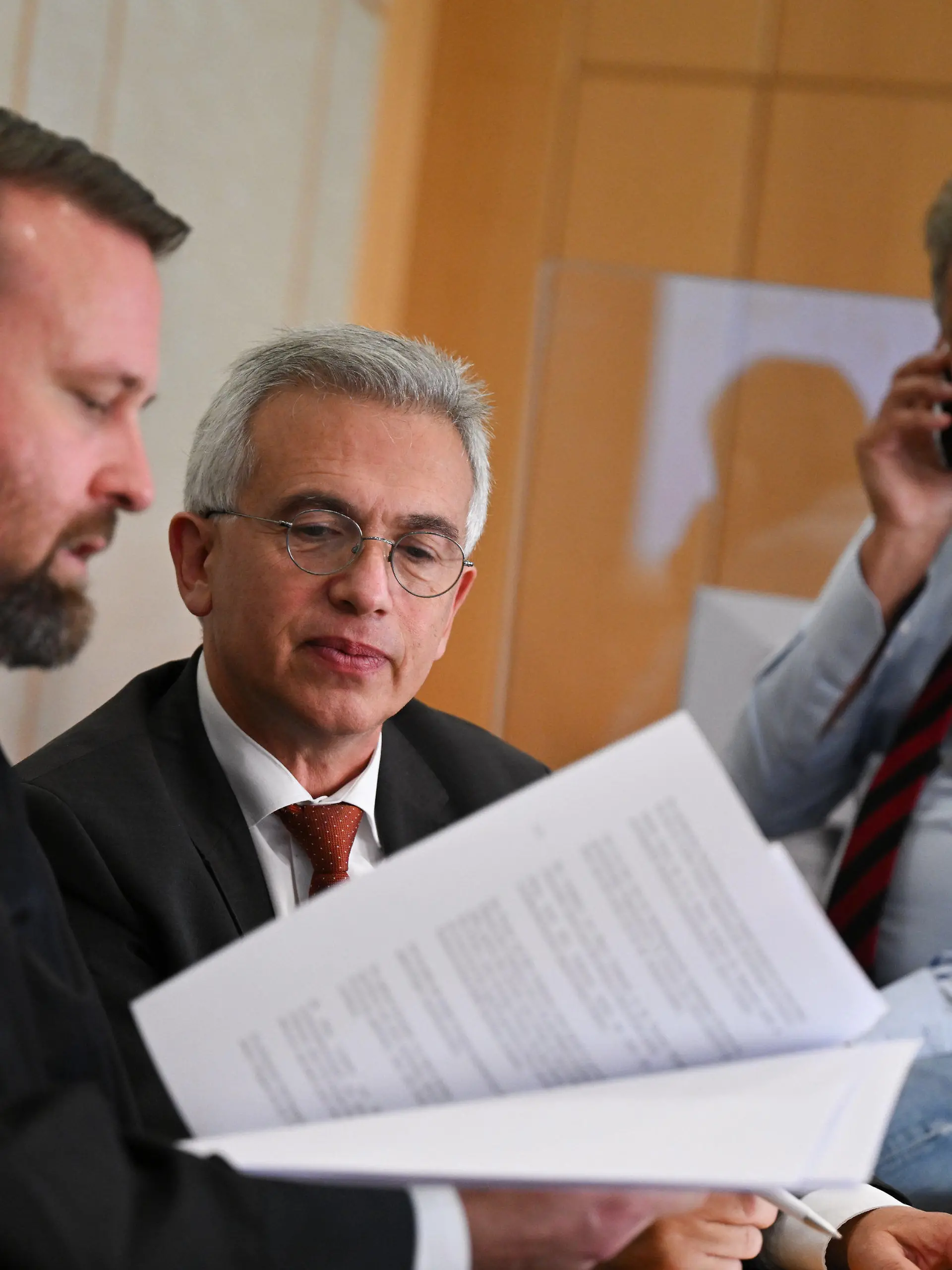 27.10.2022, Hessen, Frankfurt/Main: Peter Feldmann (SPD, M), Oberbürgermeister von Frankfurt am Main, unterhält sich während einer Pause des zweiten Prozesstages im Gerichtssaal des Landgerichts mit seinen Anwälten David Hofferbert (l) und Ulrich Endres. Der umstrittene Oberbürgermeister muss sich vor dem Landgericht wegen Korruptionsvorwürfen verantworten. Foto: Arne Dedert/dpa/POOL/dpa +++ dpa-Bildfunk +++