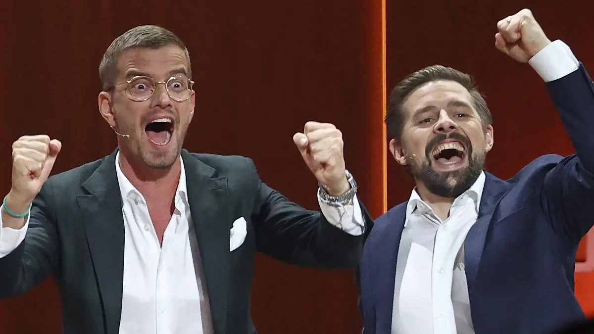 ARCHIV - 06.11.2021, Bayern, Nürnberg: Joko Winterscheidt (l) und Klaas Heufer-Umlauf jubeln in der Jubiläumsshow "Wetten, dass..?". Die Entertainer Joko Winterscheidt und Klaas Heufer-Umlauf haben irgendwo in Deutschland einen Koffer mit einer Million Euro versteckt. Bei ihrer neuen Aktion «Joko & Klaas Live: Die Schatzsuche» verstreuen die beiden Publikumslieblinge erstmals die hart erkämpfte Sendezeit auf mehrere Abende. (zu dpa «Joko und Klaas haben irgendwo einen Millionenschatz versteckt») Foto: Daniel Karmann/dpa +++ dpa-Bildfunk +++