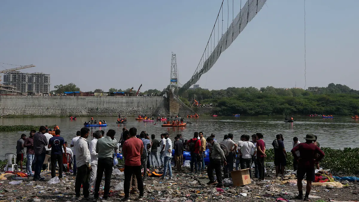 31.10.2022, Indien, Morbi: Einsatzkräfte auf Booten suchen im Fluss Machchu nach dem Einsturz einer Hängebrücke Opfern. Die Zahl der Toten beim Einsturz einer Hängebrücke über einem Fluss ist weiter gestiegen. Foto: Ajit Solanki/AP/dpa +++ dpa-Bildfunk +++