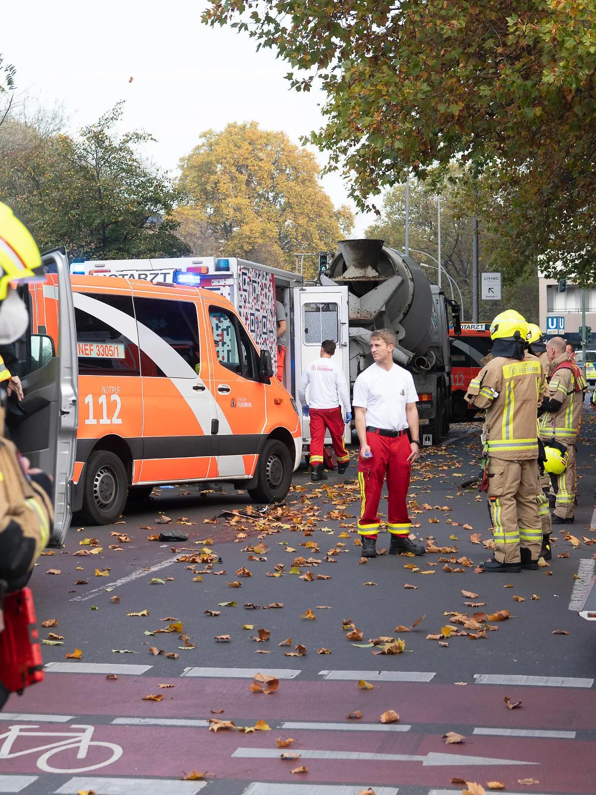 31.10.2022, Berlin: Einsatzfahrzeuge von Polizei und Feuerwehr stehen an der Bundesallee in Berlin-Wilmersdorf, wo eine Radfahrerin  bei dem Verkehrsunfall mit einem Lastwagen lebensgefährlich verletzt wurde. Die Verletzte sei unter dem Betonmischer eingeklemmt worden, teilte ein Sprecher der Feuerwehr mit. Auch der Lkw-Fahrer wurde bei dem Unfall verletzt. Einsatzkräfte der Berliner Feuerwehr sind nach Angaben eines Sprechers wegen Protesten von Klimademonstranten zudem verspätet am Unfallort eingetroffen. Foto: Paul Zinken/dpa +++ dpa-Bildfunk +++