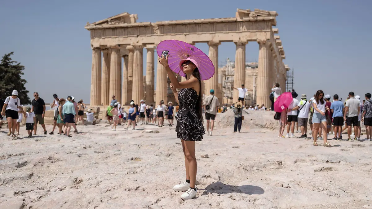 21.07.2023, Griechenland, Athen: Eine Frau macht während einer Hitzewelle ein Selfie vor dem Parthenon-Tempel auf dem Hügel der antiken Akropolis. Griechenland geht in die dritte Hitzewelle des Jahres - am Freitag (21.07.2023) sollen die Temperaturen vielerorts auf 40 Grad steigen, am Samstag (22.07.2023) auf 43 und am Sonntag (23.07.2023) in Mittelgriechenland und der Hauptstadt Athen sogar auf bis zu 44 Grad, wie es auf der staatlichen Wetterwebsite Meteo hieß. Foto: Petros Giannakouris/AP/dpa +++ dpa-Bildfunk +++