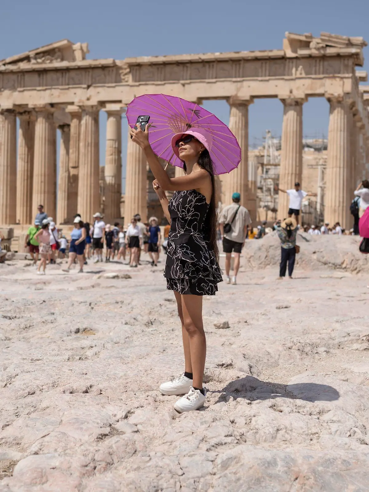 21.07.2023, Griechenland, Athen: Eine Frau macht während einer Hitzewelle ein Selfie vor dem Parthenon-Tempel auf dem Hügel der antiken Akropolis. Griechenland geht in die dritte Hitzewelle des Jahres - am Freitag (21.07.2023) sollen die Temperaturen vielerorts auf 40 Grad steigen, am Samstag (22.07.2023) auf 43 und am Sonntag (23.07.2023) in Mittelgriechenland und der Hauptstadt Athen sogar auf bis zu 44 Grad, wie es auf der staatlichen Wetterwebsite Meteo hieß. Foto: Petros Giannakouris/AP/dpa +++ dpa-Bildfunk +++