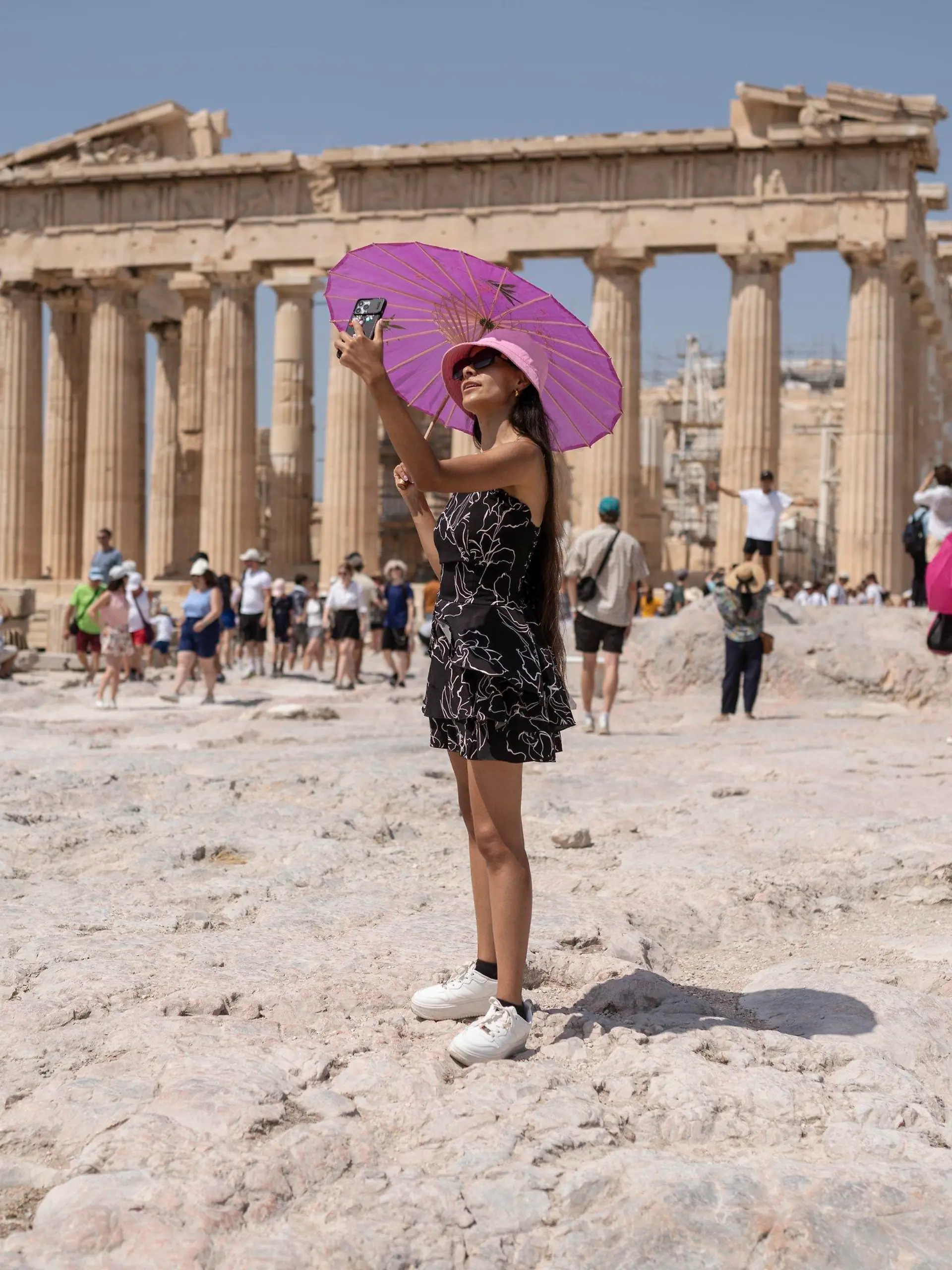 21.07.2023, Griechenland, Athen: Eine Frau macht während einer Hitzewelle ein Selfie vor dem Parthenon-Tempel auf dem Hügel der antiken Akropolis. Griechenland geht in die dritte Hitzewelle des Jahres - am Freitag (21.07.2023) sollen die Temperaturen vielerorts auf 40 Grad steigen, am Samstag (22.07.2023) auf 43 und am Sonntag (23.07.2023) in Mittelgriechenland und der Hauptstadt Athen sogar auf bis zu 44 Grad, wie es auf der staatlichen Wetterwebsite Meteo hieß. Foto: Petros Giannakouris/AP/dpa +++ dpa-Bildfunk +++