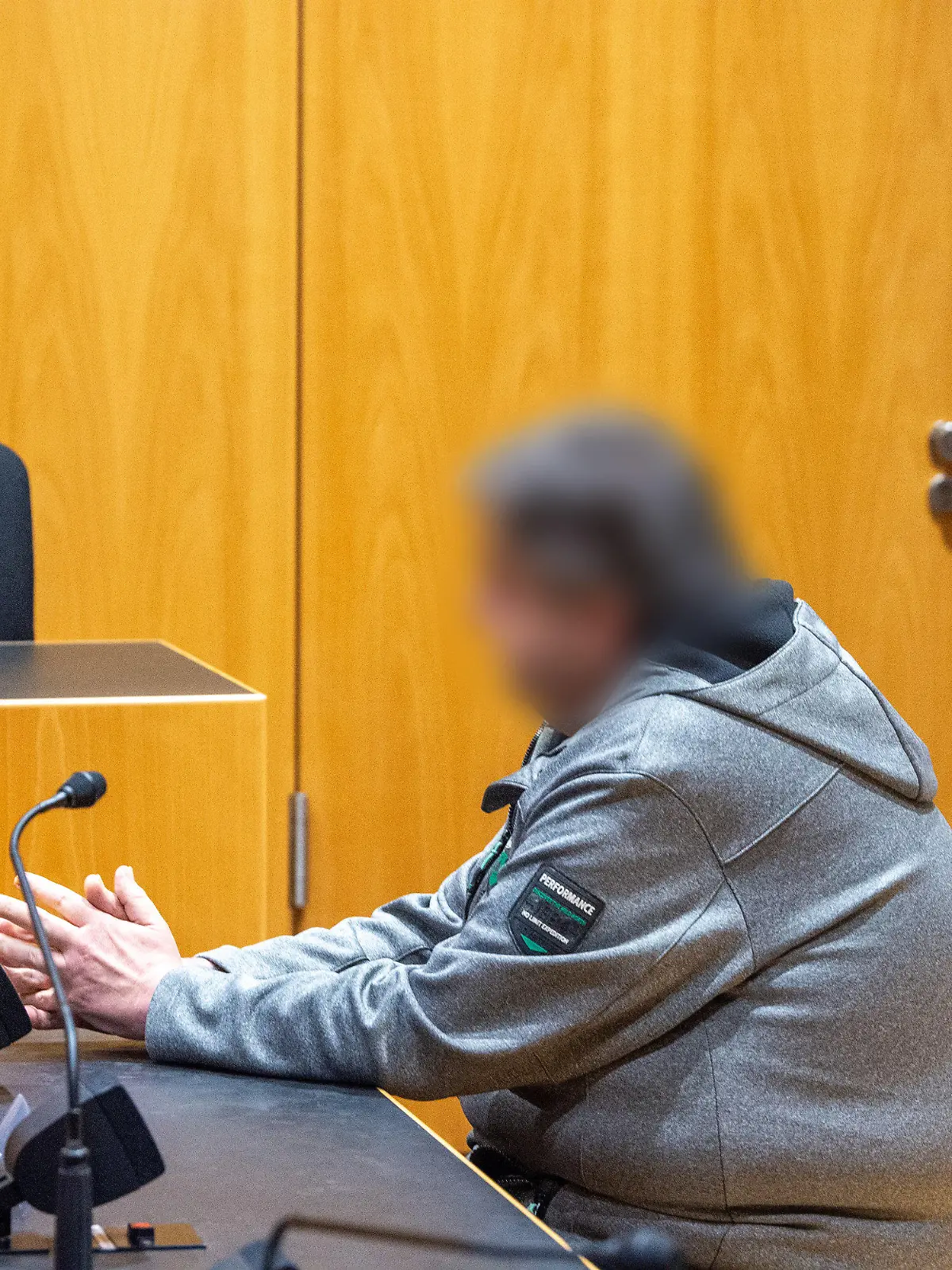 ARCHIV - 11.10.2023, Bayern, Augsburg: Ein Mann sitzt im Landgericht auf der Anklagebank. Der Angeklagte soll in einem Bereich, in dem maximal Tempo 50 erlaubt war, mit fast der dreifachen Geschwindigkeit gefahren sein, um seinen drei Mitfahrern die Leistung seines Autos zu demonstrieren. Er soll die Kontrolle über den Wagen verloren haben, von der Fahrbahn abgekommen und auf einen Möbelhaus-Parkplatz geschleudert sein. In dem Fahrzeug starb eine 21-Jährige, die beiden weiteren Mitfahrer wurden verletzt. Nun sollen die Plädoyers gehalten werden. (zu dpa «Plädoyers nach tödlichem Raser-Unfall auf Möbelhaus-Parkplatz») Foto: Stefan Puchner/dpa - ACHTUNG: Der Angeklagte wurde aus persönlichkeitsrechtlichen Gründen auf Anordnung seines Anwalts gepixelt +++ dpa-Bildfunk +++