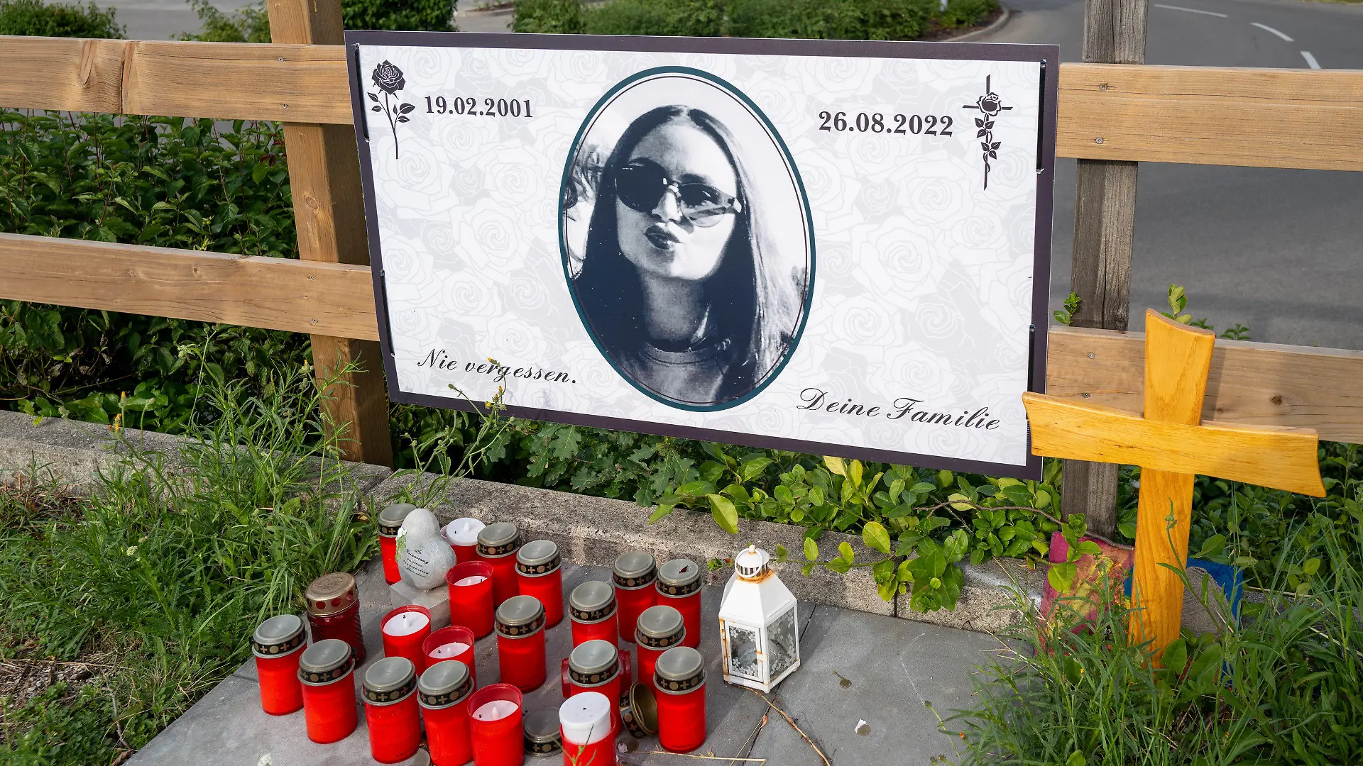 ARCHIV - 22.07.2023, Bayern, Augsburg: Die Familie einer jungen Frau, die im August 2022 bei einem mutmaßlichen Raserunfall auf einem Möbelhaus-Parkplatz starb, hat am Zaun des Parkplatzes eine Gedenkstätte eingerichtet. Wegen des tödlichen Unfalls muss sich ab Mittwoch der Fahrer vor dem Landgericht Augsburg verantworten. (zu dpa «Prozess um tödlichem Raserunfall auf Möbelhaus-Parkplatz beginnt») Foto: Ulf Vogler/dpa - ACHTUNG: Nur zur redaktionellen Verwendung im Zusammenhang mit der aktuellen Berichterstattung und nur mit vollständiger Nennung des vorstehenden Credits +++ dpa-Bildfunk +++