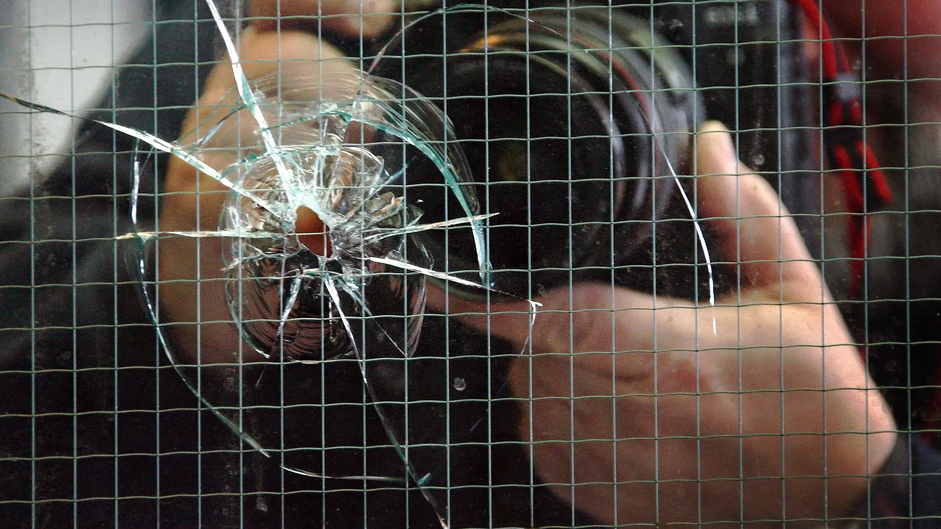 ARCHIV - Ein Bildjournalist fotografiert in Düsseldorf ein Einschussloch im Fenster einer Diskothek (Archivfoto vom 23.03.2007). Bei einer Schießerei vor dem Tanzlokal waren zuvor drei Menschen verletzt worden. Am Dienstag (08.05.2007) wird in Berlin in Anwesenheit von Bundesinnenminister Schäuble (CDU) die neue Kriminalstatistik vorgestellt. Foto: Martin Gerten dpa/lnw +++(c) dpa - Bildfunk+++