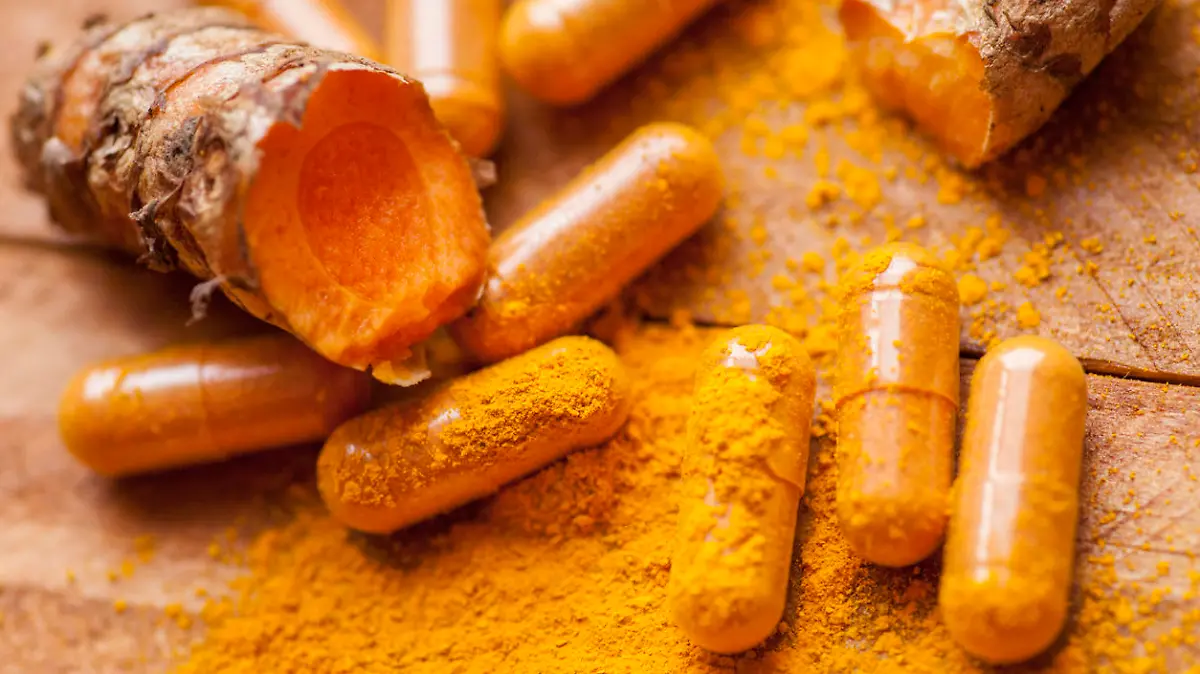 Raw organic turmeric root with powder and medicine herbal vitamin supplement pill capsules