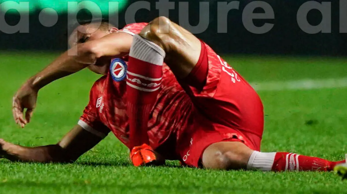 Luciano Sanchez of Argentina's Argentinos Juniors, left, grimaces after snapping his knee during a play with Marcelo of Brazil's Fluminense in a Copa Libertadores round of 16 first leg soccer match at Diego Armando Maradona stadium in Buenos Aires, Argentina, Tuesday, Aug. 1, 2023. (AP Photo/Ivan Fernandez)