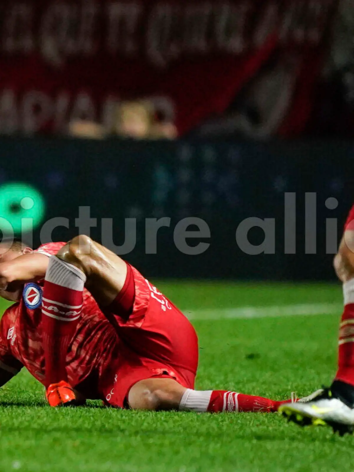 Luciano Sanchez of Argentina's Argentinos Juniors, left, grimaces after snapping his knee during a play with Marcelo of Brazil's Fluminense in a Copa Libertadores round of 16 first leg soccer match at Diego Armando Maradona stadium in Buenos Aires, Argentina, Tuesday, Aug. 1, 2023. (AP Photo/Ivan Fernandez)