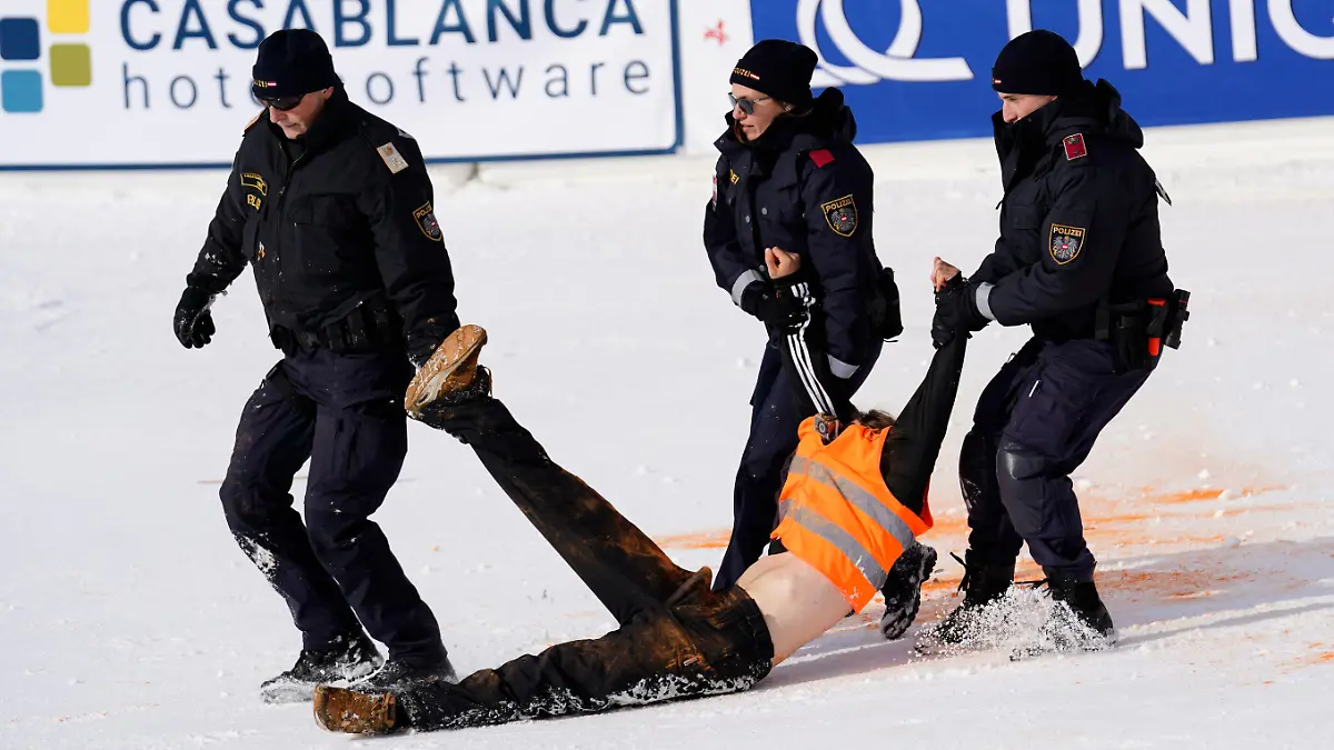 18.11.2023, Österreich, Gurgl: Ski alpin: Weltcup, Slalom, Herren, Proteste: Ein Demonstranten der Letzten Generation wird weggetragen, nachdem er im Zielbereich orangene Farbe versprüht hat. Foto: Piermarco Tacca/AP/dpa +++ dpa-Bildfunk +++