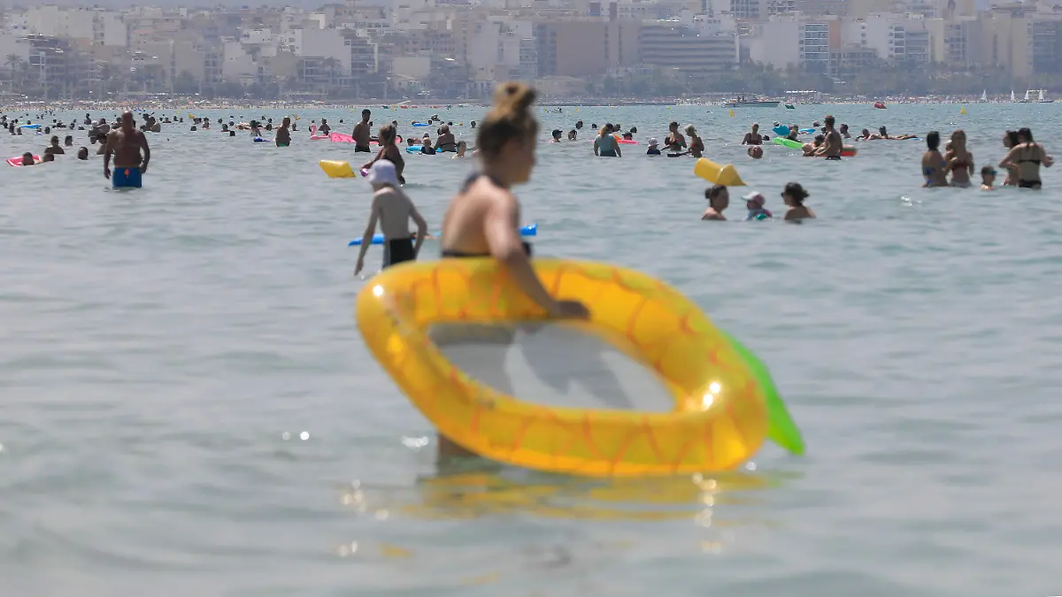 18.07.2023, Spanien, Palma de Mallorca: Menschen kühlen sich bei heißen Temperaturen am Strand von Arenal ab. Für den Norden und Osten der spanischen Mittelmeer-Insel Mallorca kündigte der nationale Wetterdienst Aemet Höchsttemperaturen von mindestens 43 Grad an. Der Höhepunkt der dritten Hitzewelle des Sommers in Spanien bringt Einheimische und Touristen im beliebten Urlaubsland ins Schwitzen. Foto: Clara Margais/dpa +++ dpa-Bildfunk +++