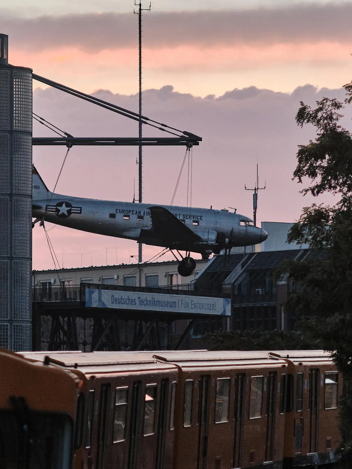 Eine U-Bahn der Berliner Verkehrsbetriebe (BVG) fährt auf der Hochbahnstrecke aus der Richtung des Deutschen Technikmuseums, auf dessen Dach ein Flugzeug des Typs Douglas C-47, «Rosinenbomber» genannt, steht, in den U-Bahnhof Möckernbrücke im Stadtteil Kreuzberg ein.