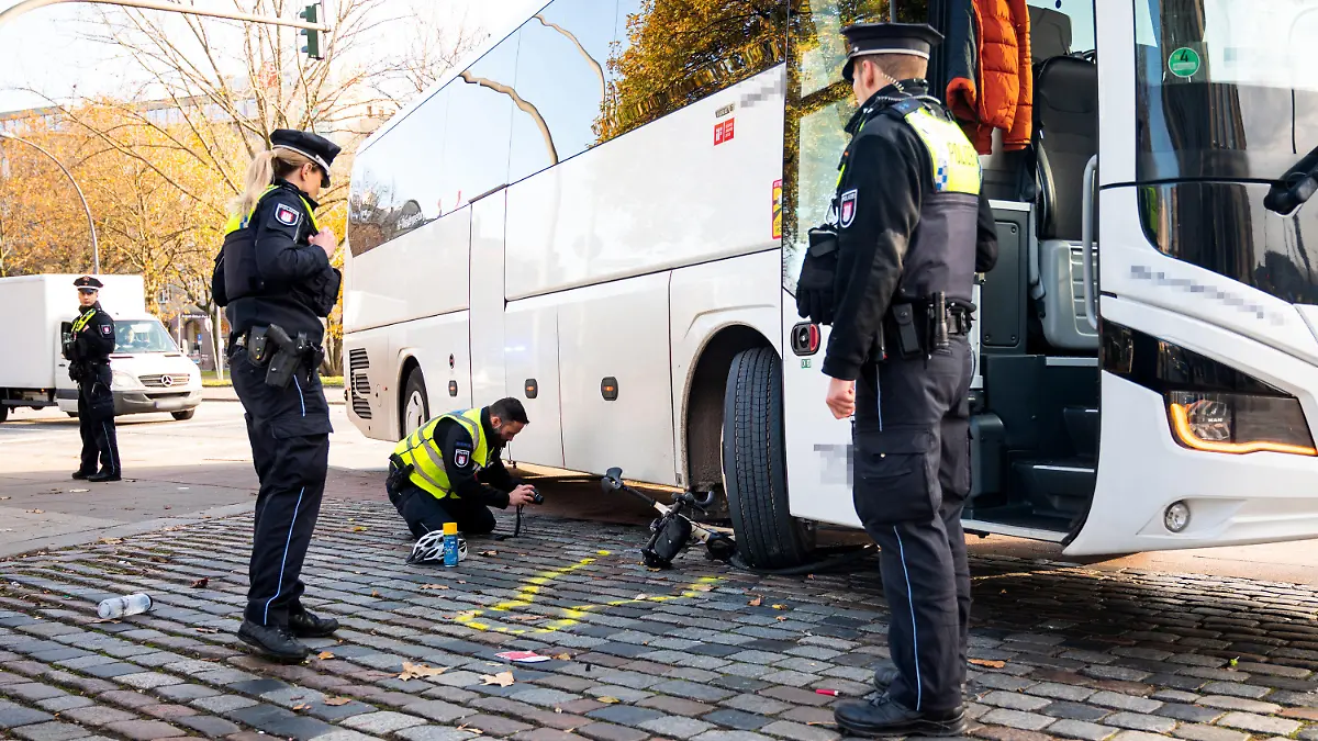 18.11.2023, Hamburg: Einsatzkräfte stehen nach einem Unfall mit einem Radfahrer und einem Reisebus am Unfallort. Beim Rechtsabbiegen hat der Bus einen Radfahrer übersehen und schwer verletzt. Der Radfahrer wurde ins Krankenhaus gebracht, wo er wenig später seinen Verletzungen erlegen sei. Foto: Daniel Bockwoldt/dpa +++ dpa-Bildfunk +++