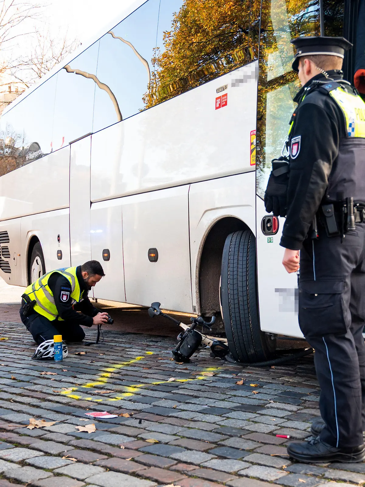 18.11.2023, Hamburg: Einsatzkräfte stehen nach einem Unfall mit einem Radfahrer und einem Reisebus am Unfallort. Beim Rechtsabbiegen hat der Bus einen Radfahrer übersehen und schwer verletzt. Der Radfahrer wurde ins Krankenhaus gebracht, wo er wenig später seinen Verletzungen erlegen sei. Foto: Daniel Bockwoldt/dpa +++ dpa-Bildfunk +++