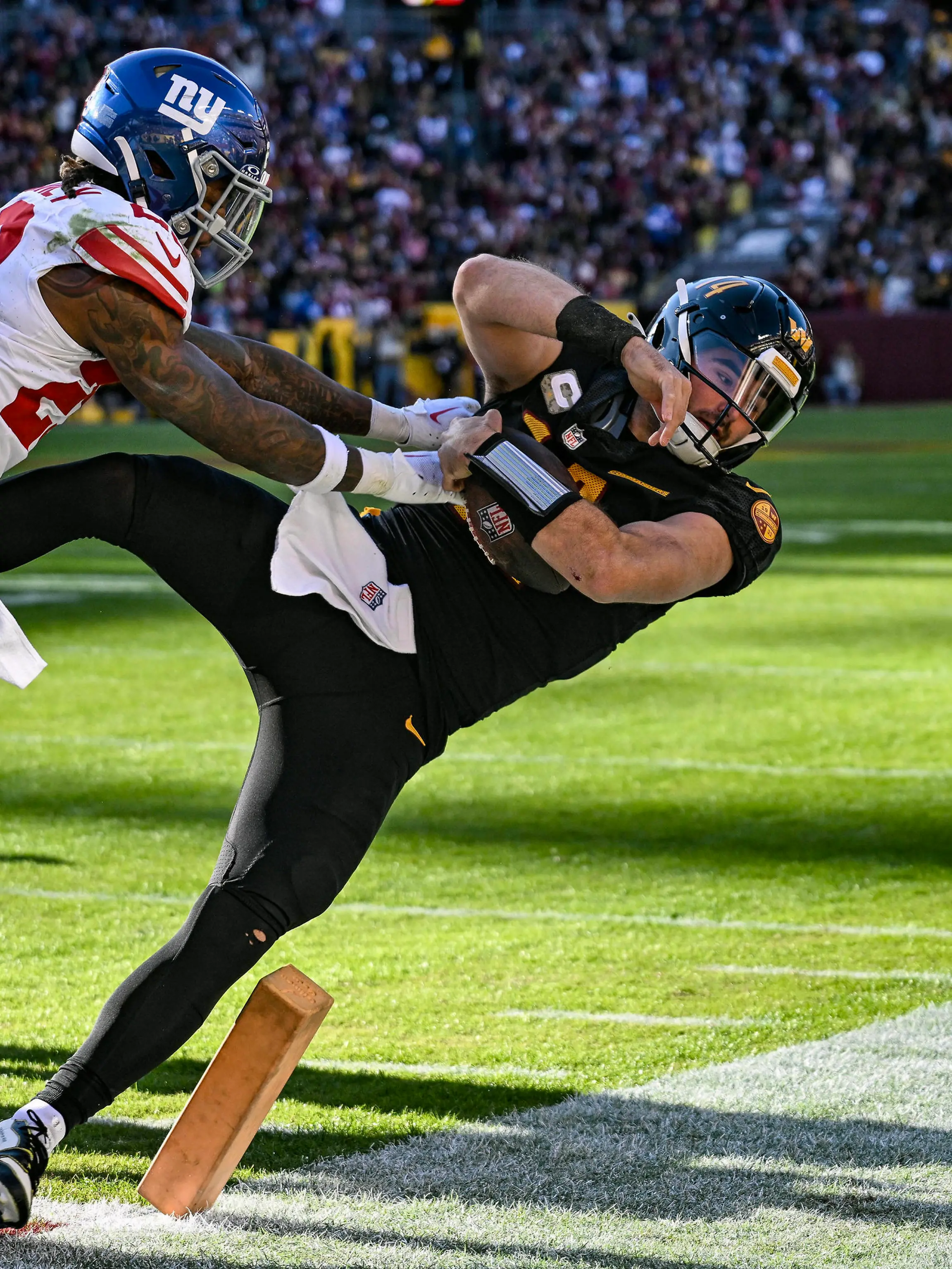 LANDOVER, MD - NOVEMBER 19: Washington Commanders quarterback Sam Howell 14 runs for a touchdown against New York Giants safety Xavier McKinney 29 during the NFL, American Football Herren, USA game between the New York Giants and the Washington Commanders on November 19, 2023 at Fed Ex Field in Landover, MD. Photo by Mark Goldman/Icon Sportswire NFL: NOV 19 Giants at Commanders EDITORIAL USE ONLY Icon74923111914