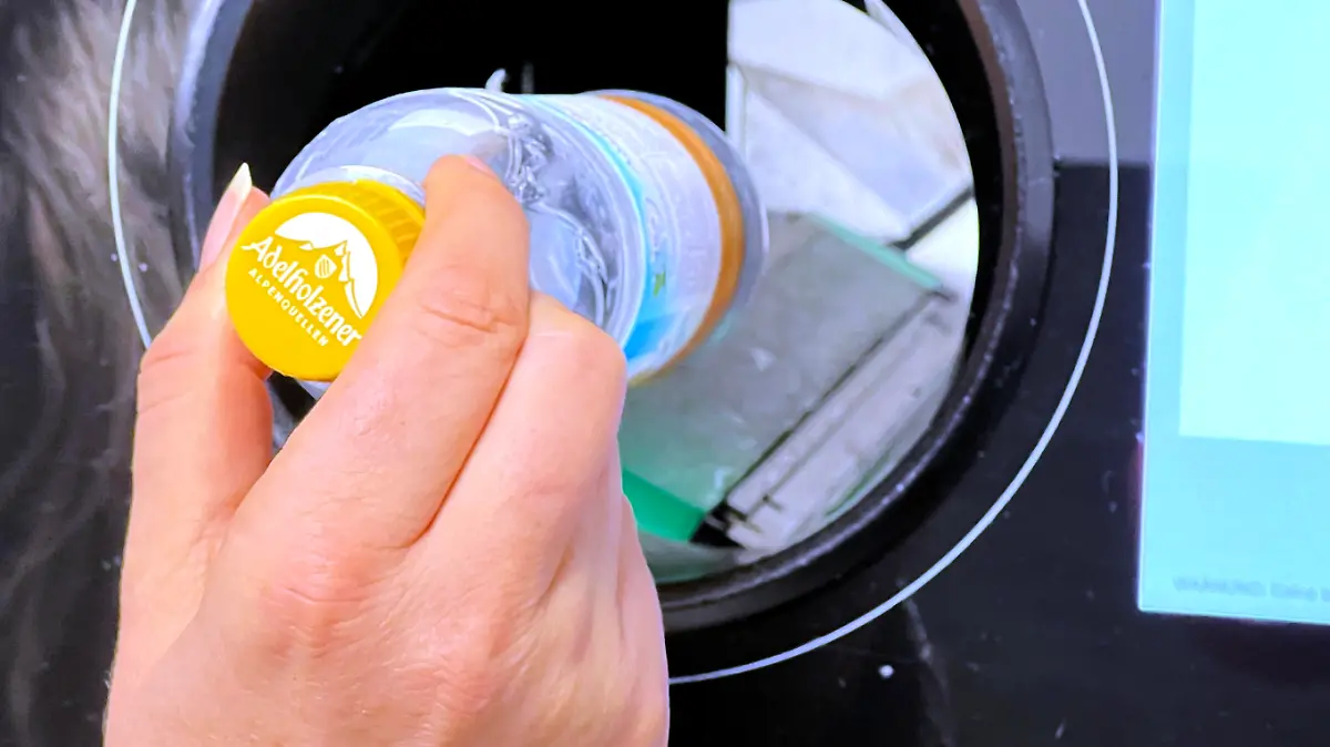 21.12.2021, Pfand-Automat in einem Supermarkt im Unterallgaeu, eine Frau wirft eine Plastik-Pfandflasche ein. || Mindestpreis 20 Euro