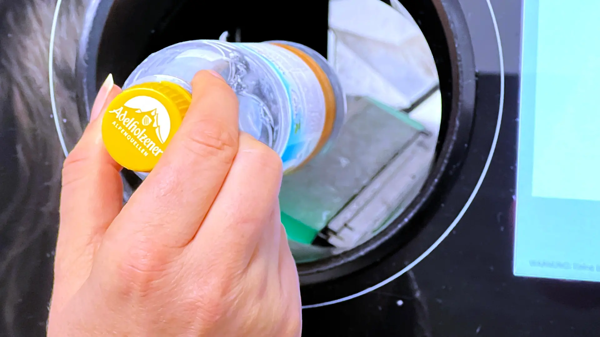 21.12.2021, Pfand-Automat in einem Supermarkt im Unterallgaeu, eine Frau wirft eine Plastik-Pfandflasche ein. || Mindestpreis 20 Euro