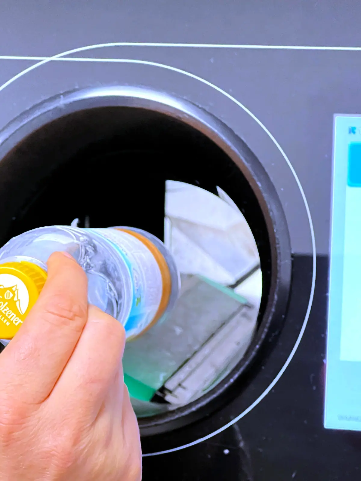 21.12.2021, Pfand-Automat in einem Supermarkt im Unterallgaeu, eine Frau wirft eine Plastik-Pfandflasche ein. || Mindestpreis 20 Euro 