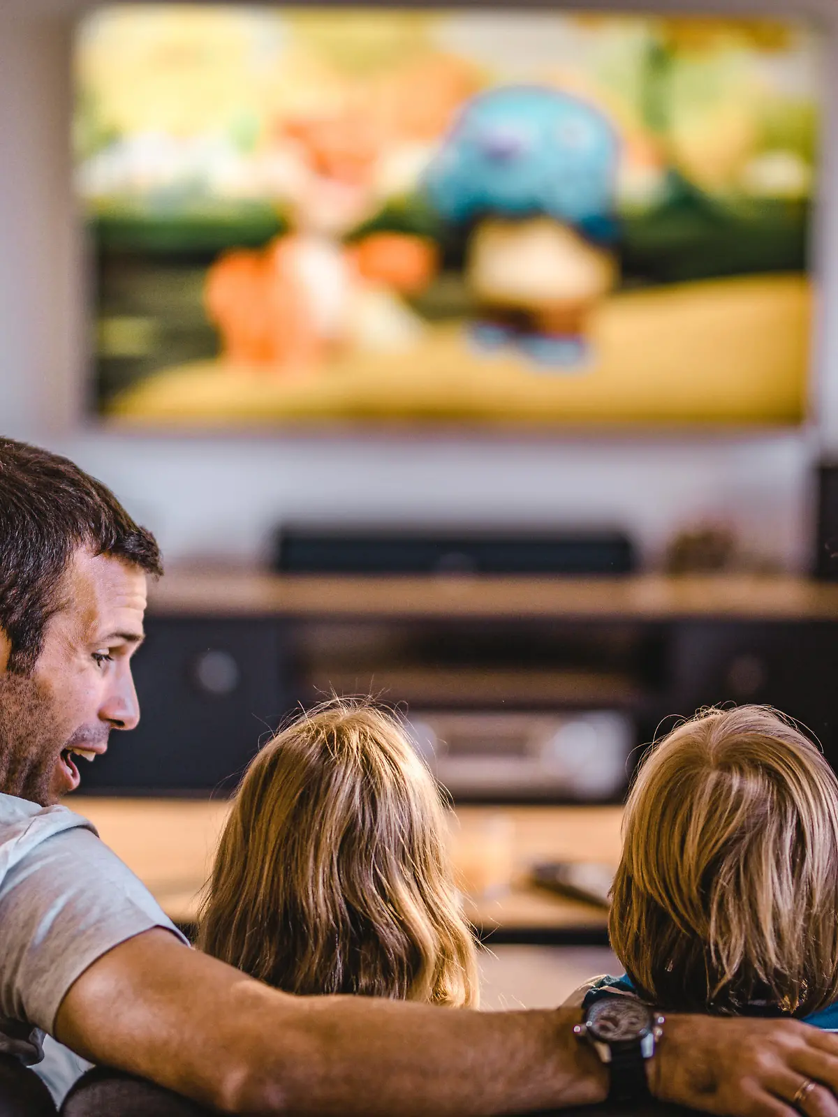 Fröhliche Familie sitzt vor dem Fernseher