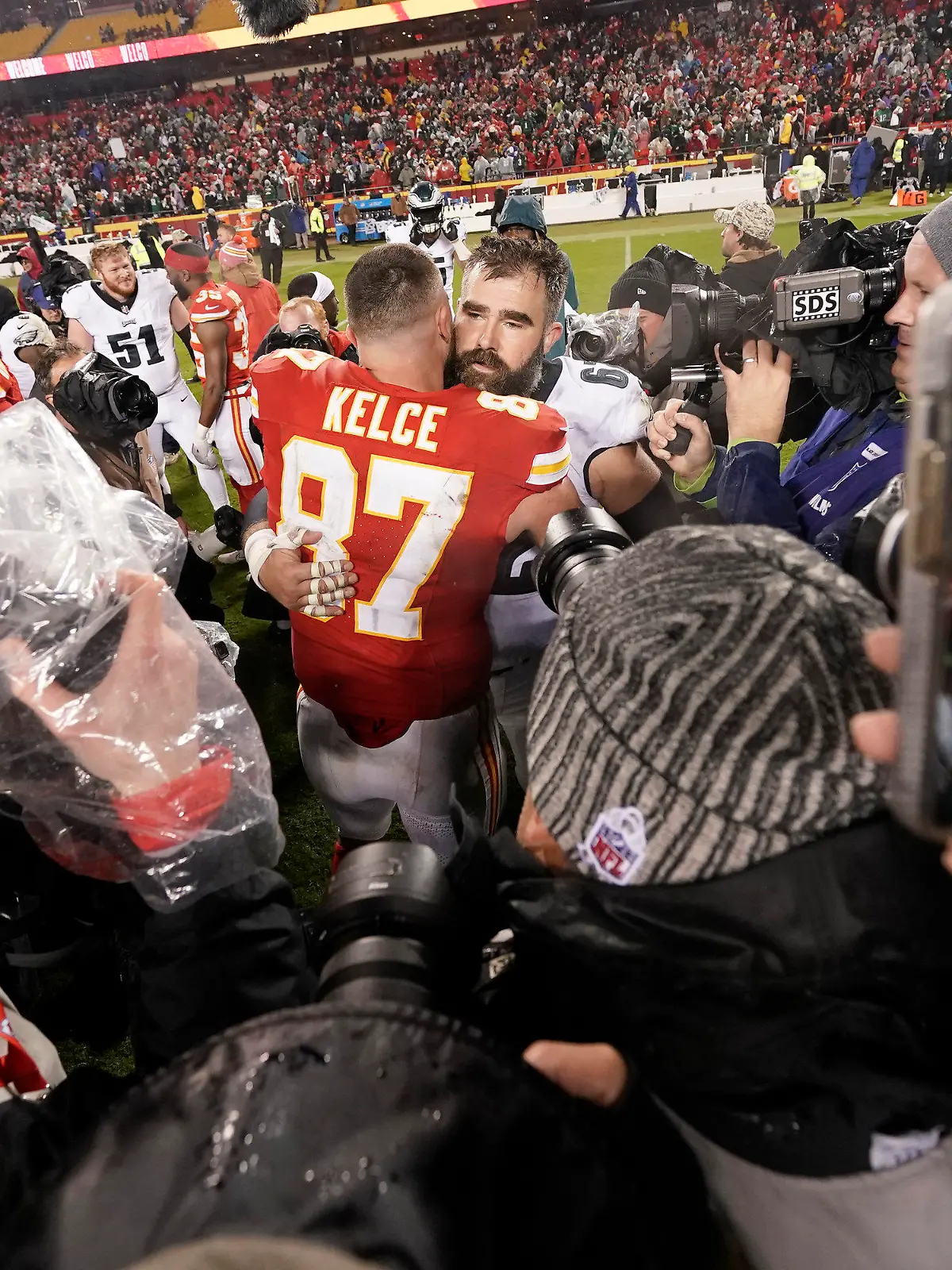 20.11.2023, USA, Kansas City: American Football: Profiliga NFL, Hauptrunde, Kansas City Chiefs - Philadelphia Eagles. Kansas City Chiefs Tight End Travis Kelce (87) umarmt seinen Bruder, Philadelphia Eagles Center Jason Kelce nach dem Spiel. Foto: Charlie Riedel/AP +++ dpa-Bildfunk +++