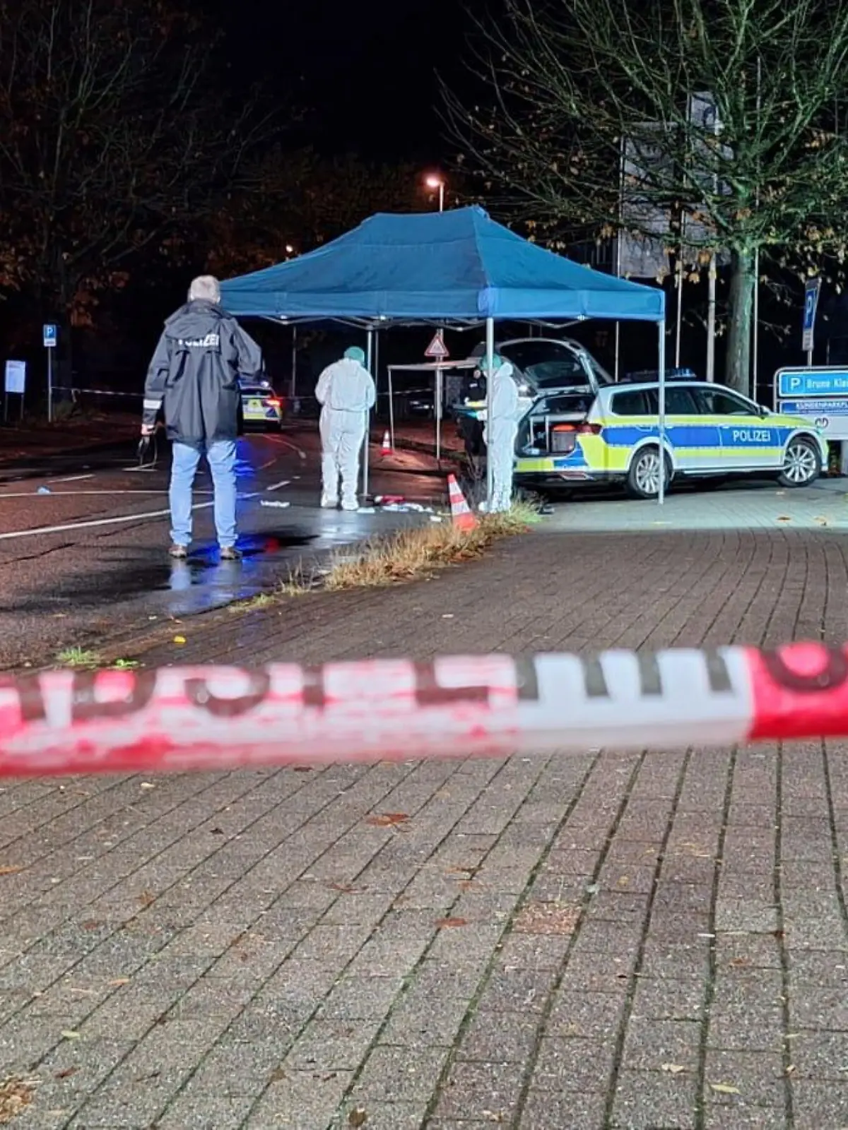 20.11.2023, Niedersachsen, Delmenhorst: Polizisten untersuchen den Tatort. Ein mit einer Axt bewaffneter Mann ist in Delmenhorst von der Polizei angeschossen und schwer verletzt worden. Der Mann soll die Beamten zuvor angegriffen haben, teilte die Polizei auf der Online-Plattform X mit. Der Tatort wurde demnach abgesperrt. Nach Angaben der Ermittler soll der Mann zuvor in einem Wohnhaus randaliert haben. Foto: Nord-West-Media TV/dpa +++ dpa-Bildfunk +++