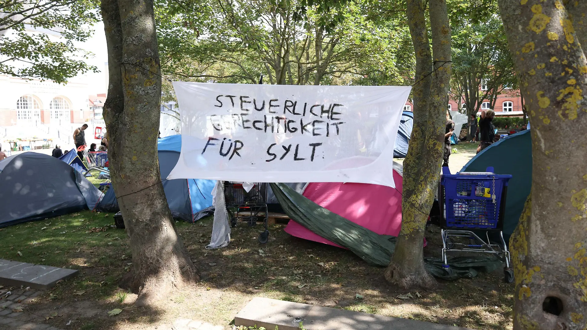 Protestcamp von Punkern und linken Aktivisten auf dem Rathausplatz in Westerland auf Sylt. Vom 1. August bis zum 14 August campieren die Gruppen von Aktion Sylt in Zelten unter dem Motto: Sylt für alle gegen Gentrifizierung und die Abschottung der Reichen auf der Lieblingsinsel der Reichen. Rund 90 Personen demonstrien auf der Urlaubsinsel Sylt unter dem Motto Sylt gehört dem Pöbel durch Westerland. Nur wenig Teilnehmerinnen und Teilnehmer folgten dem Aufruf der Hamburger Gruppe Schwarz-Roter 1. Mai, die eigentlich zum Protest gegen einen Neonazi-Aufmarsch mobilisiert hat. Nach einer Absprache zogen die Demonstraten friedlich vom Bahnhof vor das Rathaus der Nordseeinsel, wo seit einigen Tagen ein Protestcamp linker Personen und
