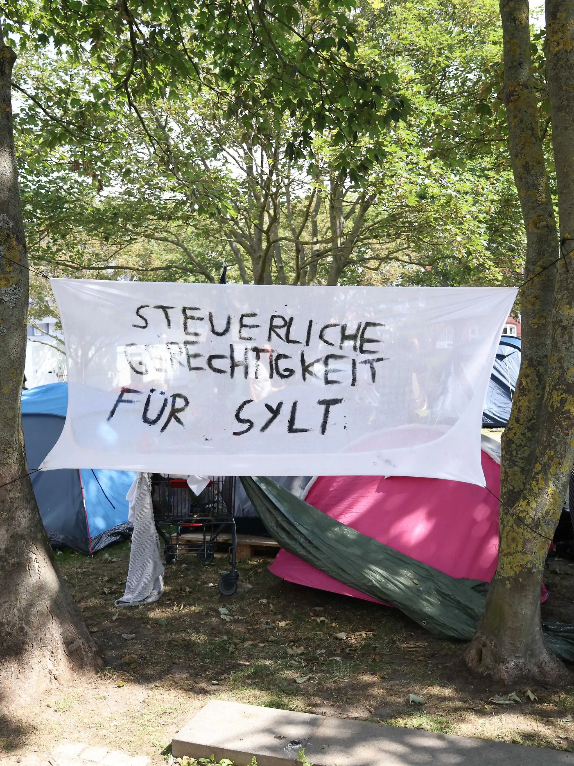  Protestcamp von Punkern und linken Aktivisten auf dem Rathausplatz in Westerland auf Sylt. Vom 1. August bis zum 14 August campieren die Gruppen von Aktion Sylt in Zelten unter dem Motto: Sylt für alle gegen Gentrifizierung und die Abschottung der Reichen auf der Lieblingsinsel der Reichen. Rund 90 Personen demonstrien auf der Urlaubsinsel Sylt unter dem Motto Sylt gehört dem Pöbel durch Westerland. Nur wenig Teilnehmerinnen und Teilnehmer folgten dem Aufruf der Hamburger Gruppe Schwarz-Roter 1. Mai, die eigentlich zum Protest gegen einen Neonazi-Aufmarsch mobilisiert hat. Nach einer Absprache zogen die Demonstraten friedlich vom Bahnhof vor das Rathaus der Nordseeinsel, wo seit einigen Tagen ein Protestcamp linker Personen und