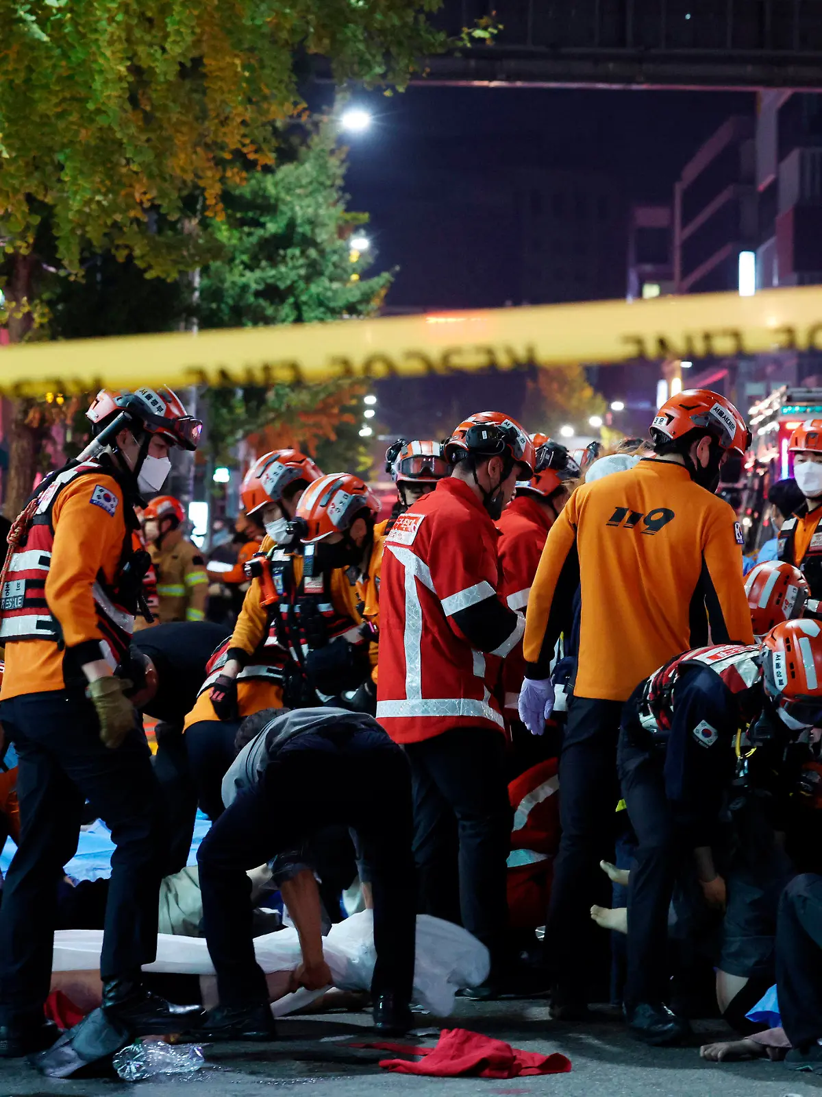 29.10.2022, Südkorea, Seoul: Rettungskräfte und Feuerwehrleute sind an der Unfallstelle im Einsatz. Dutzende Personen haben beim Ansturm auf Halloween-Feierlichkeiten in Seoul einen Herzstillstand erlitten. Wie die südkoreanische Nachrichtenagentur Yonhap berichtete, mussten Notfallkräfte bei mindestens 50 Menschen Wiederbelebungsmaßnahmen durchführen. Foto: Lee Ji-Eun/Yonhap/AP/dpa +++ dpa-Bildfunk +++