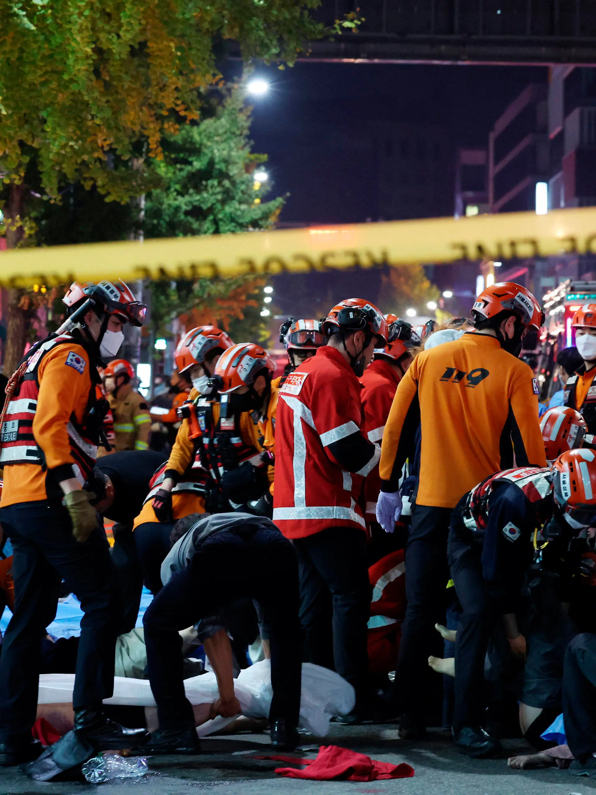 29.10.2022, Südkorea, Seoul: Rettungskräfte und Feuerwehrleute sind an der Unfallstelle im Einsatz. Dutzende Personen haben beim Ansturm auf Halloween-Feierlichkeiten in Seoul einen Herzstillstand erlitten. Wie die südkoreanische Nachrichtenagentur Yonhap berichtete, mussten Notfallkräfte bei mindestens 50 Menschen Wiederbelebungsmaßnahmen durchführen. Foto: Lee Ji-Eun/Yonhap/AP/dpa +++ dpa-Bildfunk +++