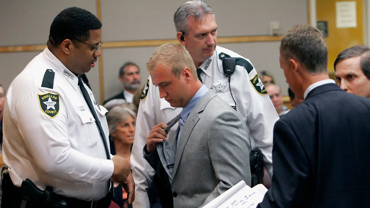 Nick Bollea removes his tie as Pinellas County Sheriff's bailiffs prepare to take him into custody after he was sentenced to eight months in county jail, Friday, May 9, 2008, in Clearwater, Fla. The 17-year-old son of wrestling superstar Hulk Hogan was sentenced to eight months in county jail after he pleaded no contest to causing a crash that seriously injured his best friend. (AP Photo/Pool, Joseph Garentt Jr.)